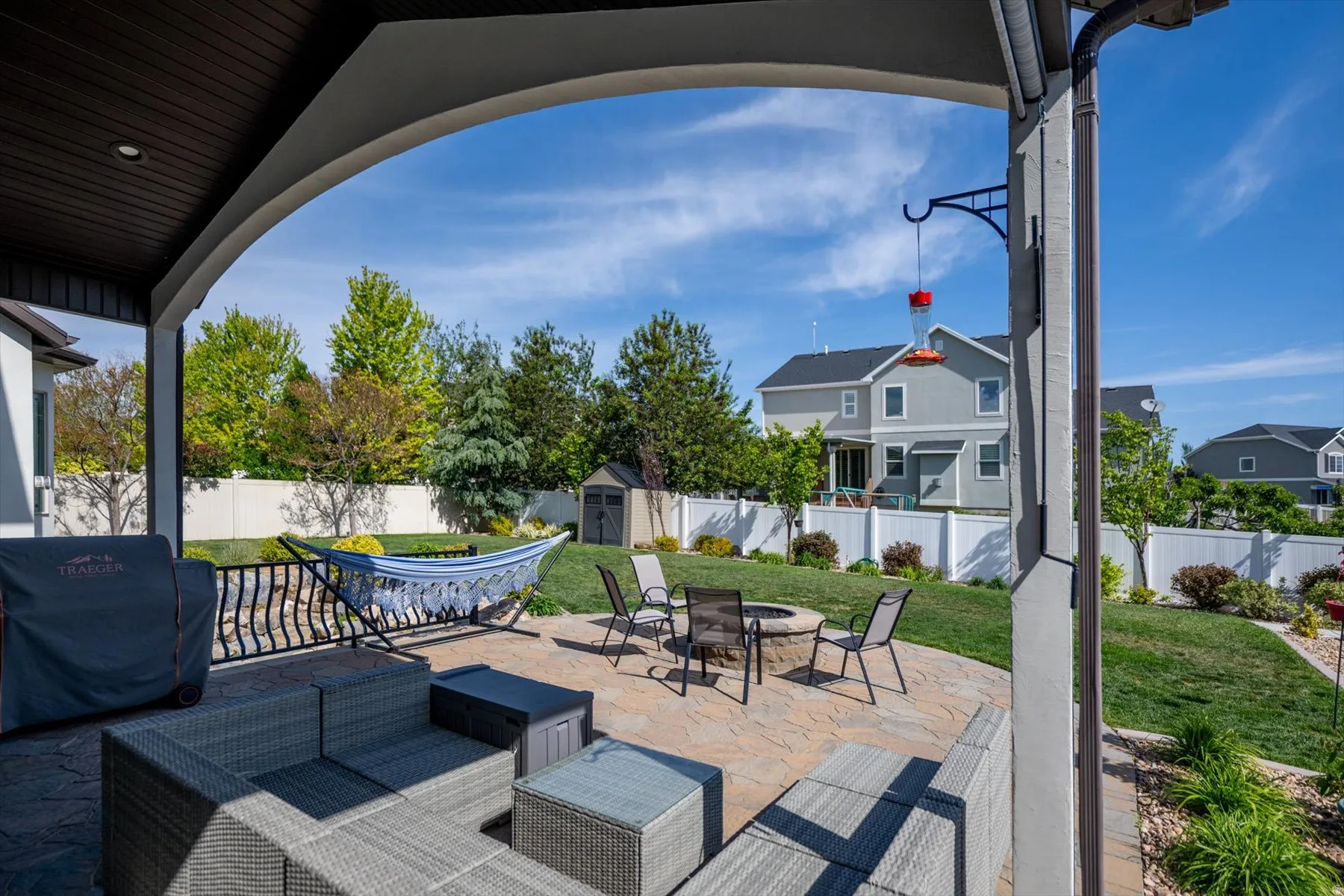 Covered patio featuring an arched entryway and dark wood-finish ceiling