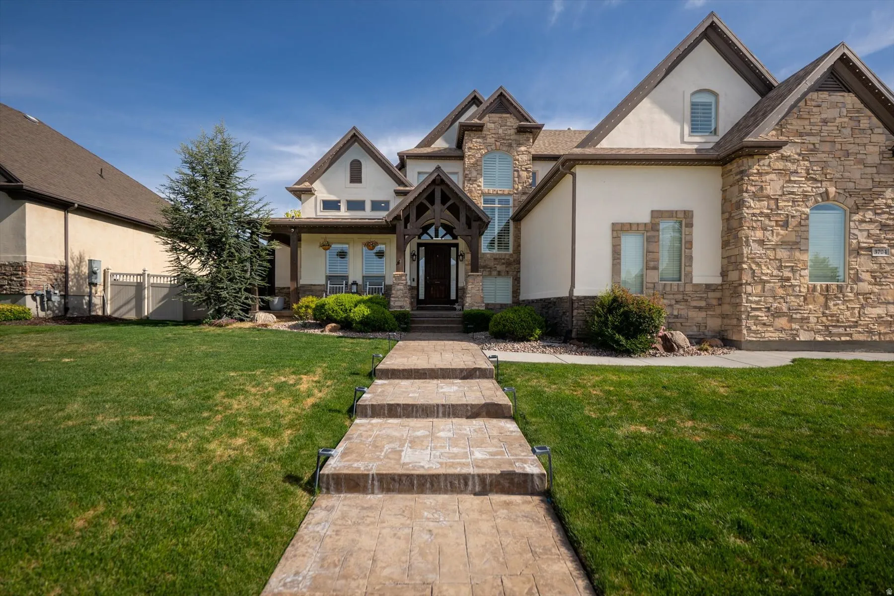 Stone and stucco exterior featuring a gabled roofline