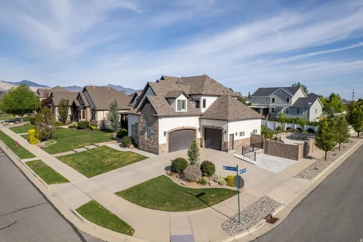 Corner lot residence featuring a multi-tone stone and stucco exterior, a two-car garage, and a separate single-car garage