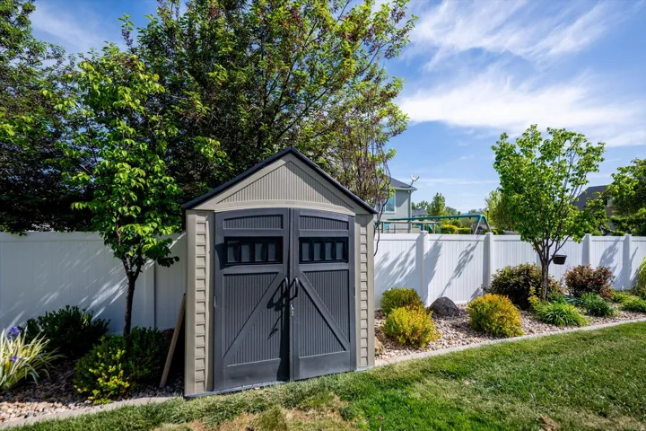 Outdoor storage shed featuring a dual-tone exterior, double doors, and a gable roof