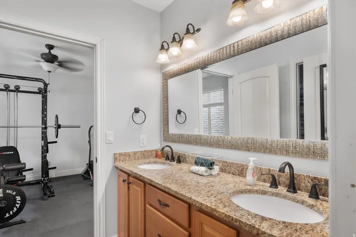 Full bathroom with dual vanity with granite-style countertop, undermount sinks, and oil-rubbed bronze fixtures