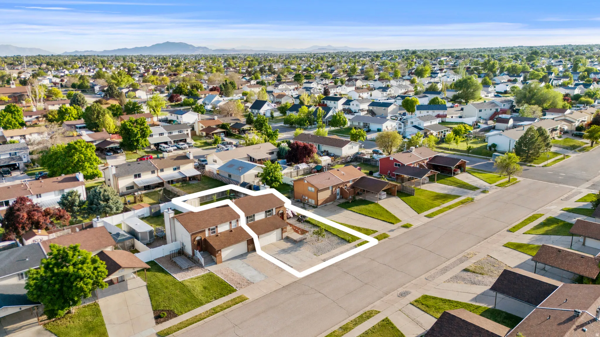 Suburban street with residential properties featuring attached garages and established landscaping