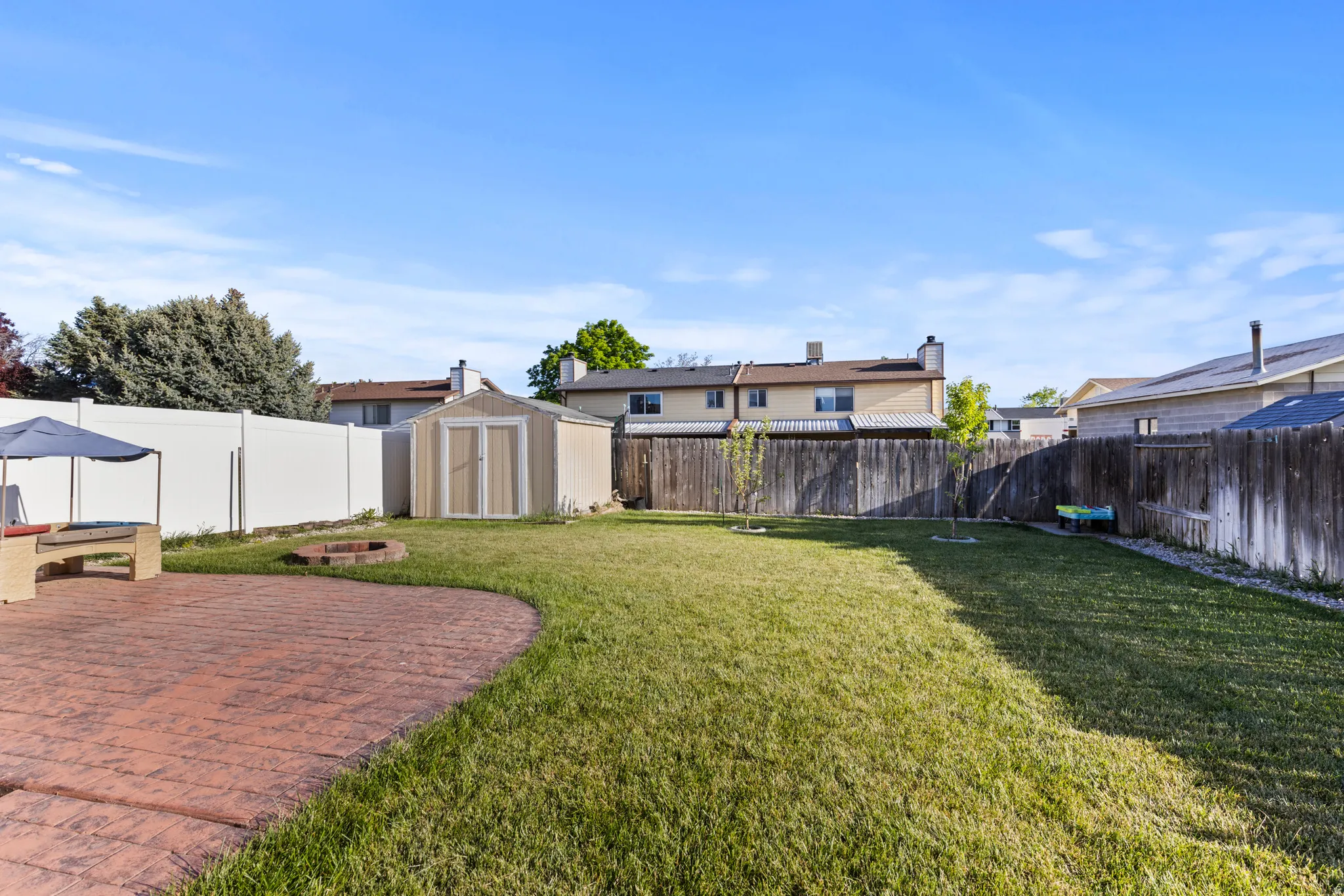 Expansive backyard featuring a curved stamped concrete patio and a manicured lawn