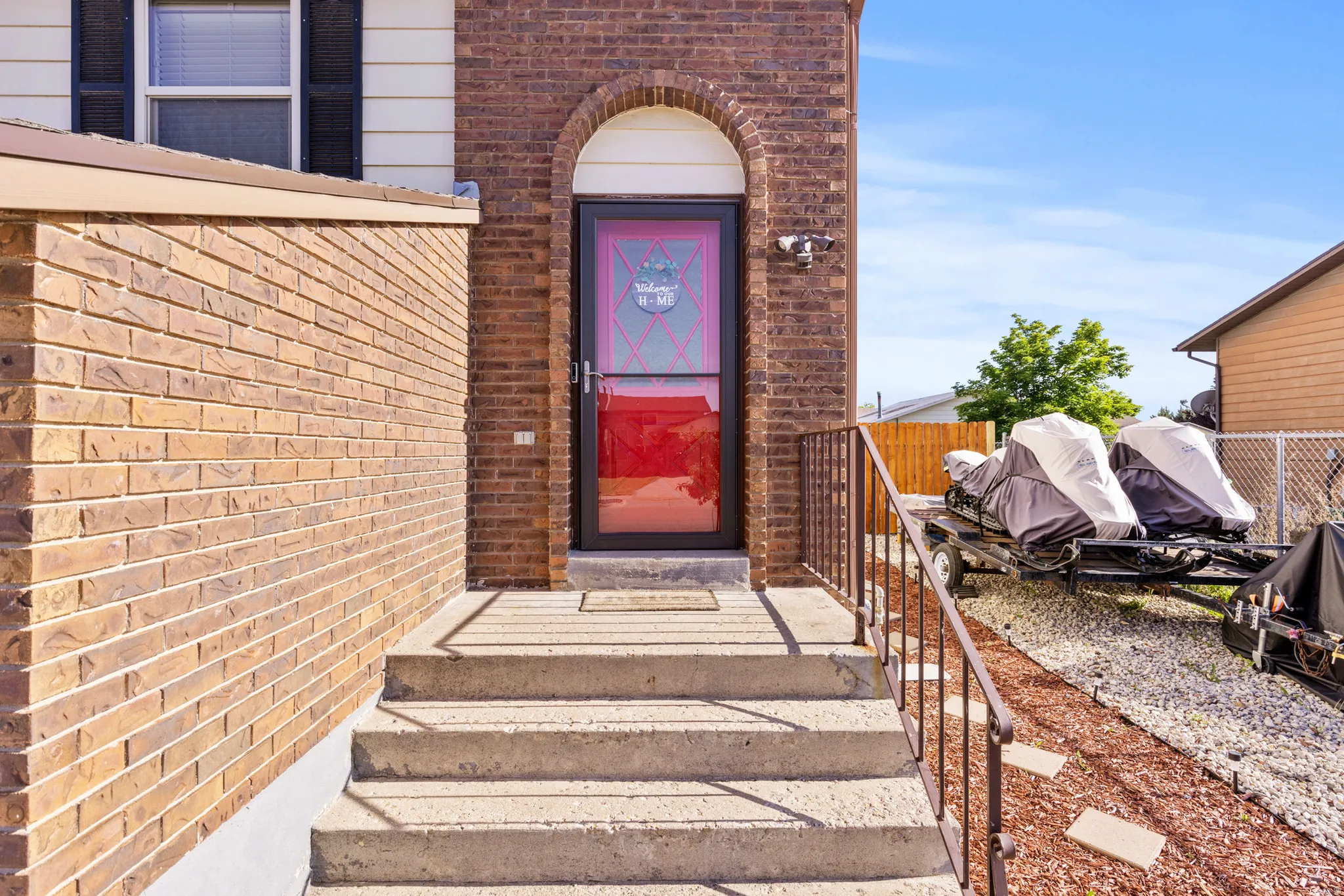 Brick facade with an arched entryway and concrete steps