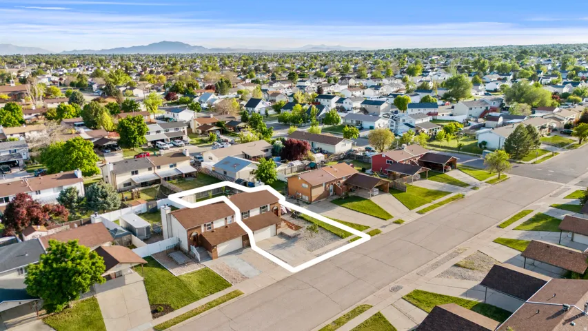 Suburban street with residential properties featuring attached garages and established landscaping