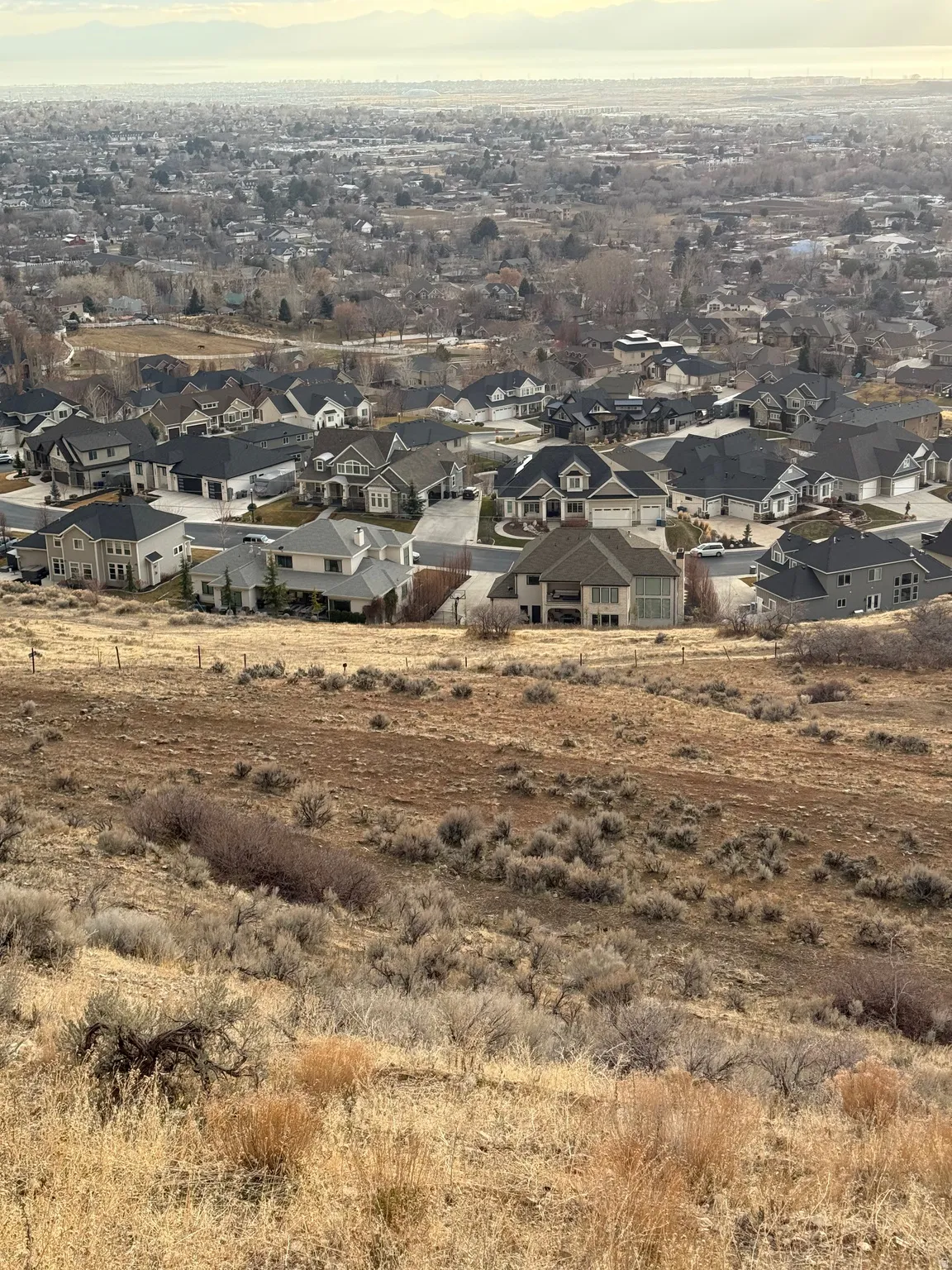 Expansive undeveloped land featuring natural grasses and brush, offering a sloping terrain