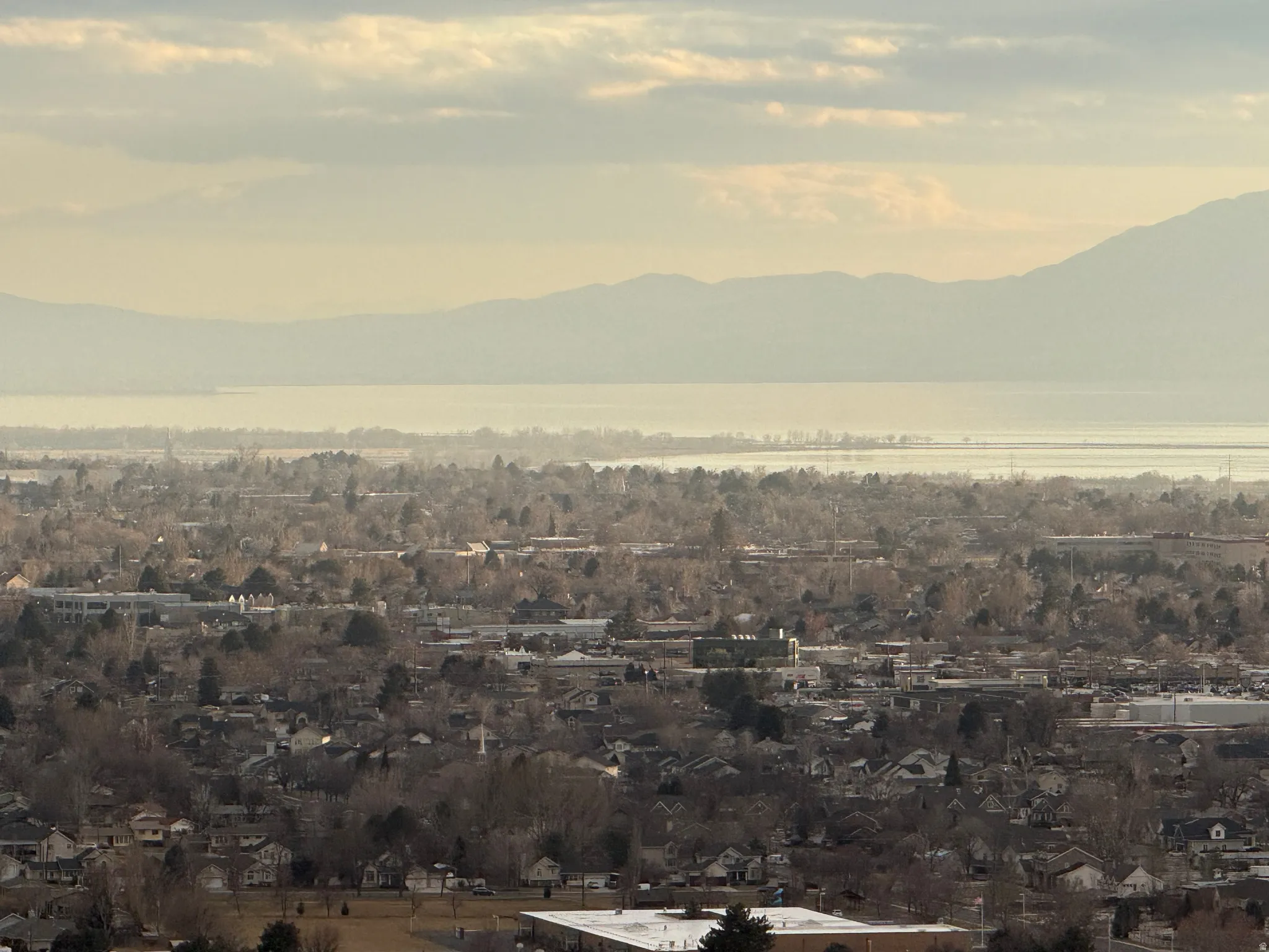 Elevated perspective showcasing a broad urban landscape with distant mountains and a body of water