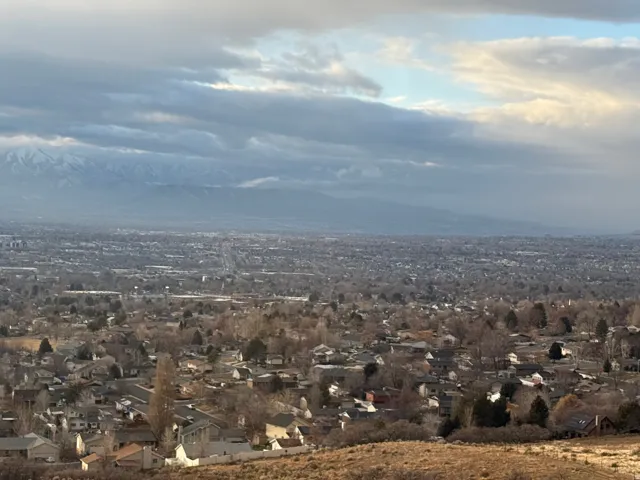 Expansive elevated city landscape with distant snow-capped mountains