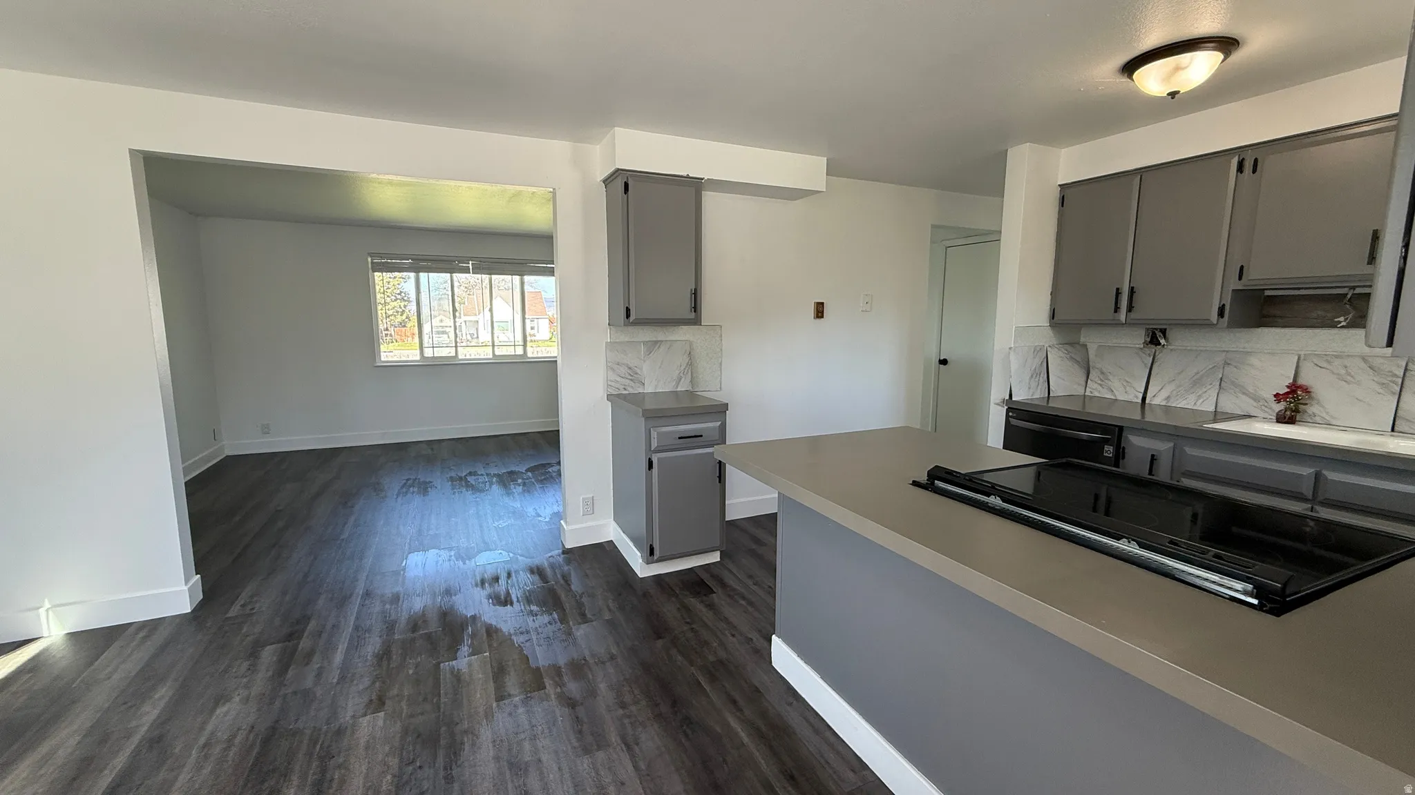 Kitchen featuring gray cabinetry, light countertops, and a built-in cooktop