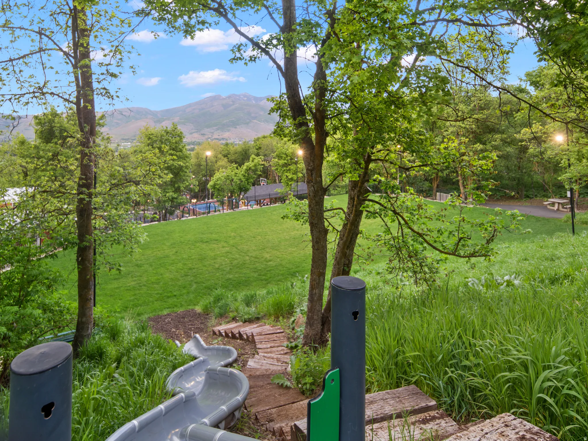 Expansive green spaces featuring mature trees and mountain scenery