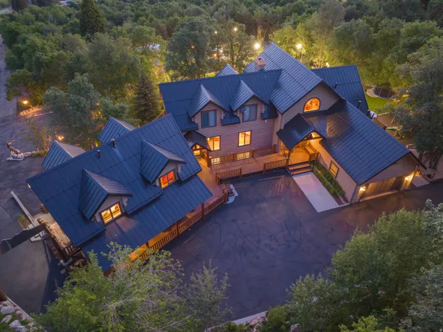 Expansive property featuring a multi-level structure with a dark metal roof and light-toned siding