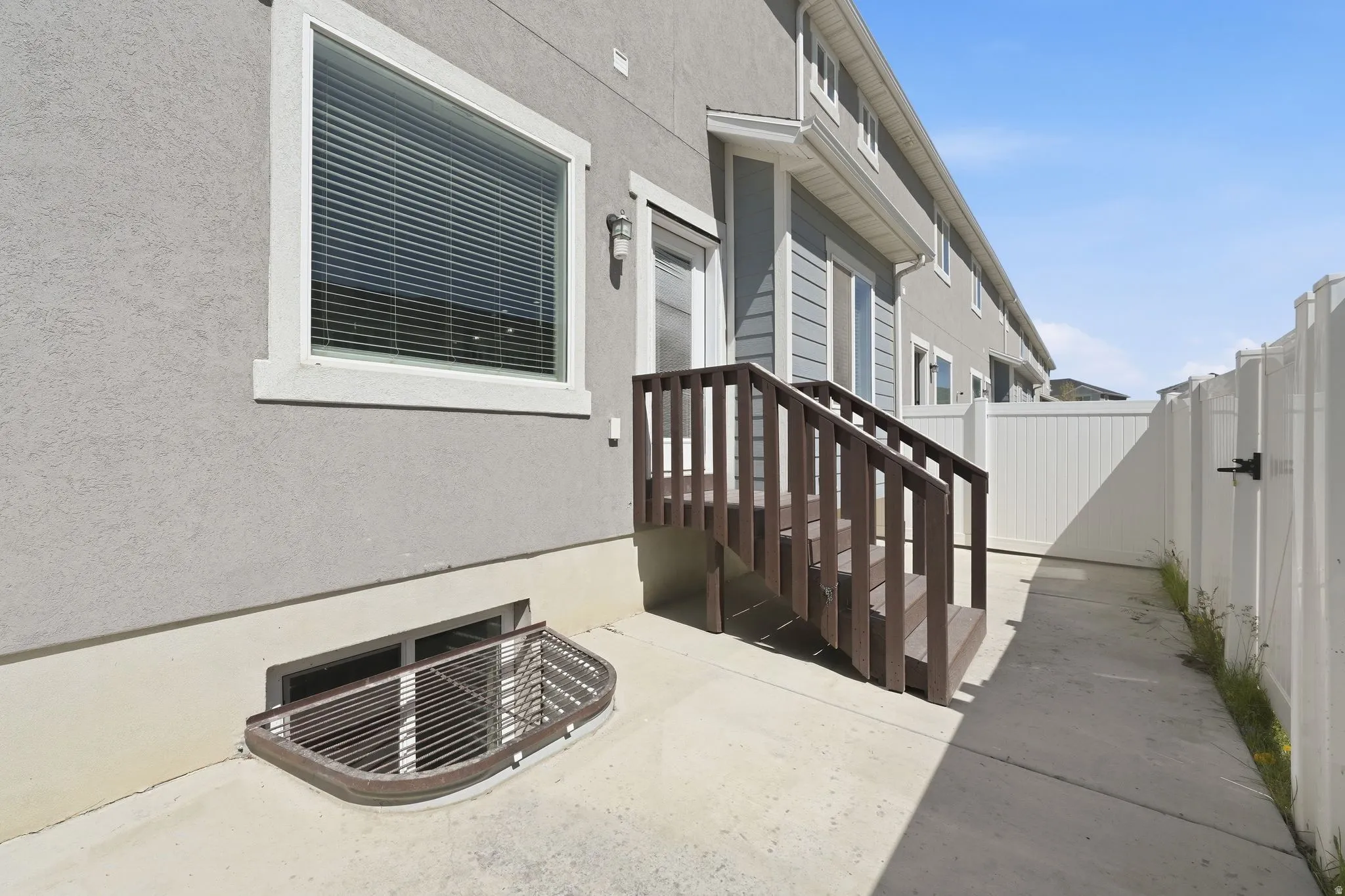 Concrete patio with direct outdoor access via wooden staircase