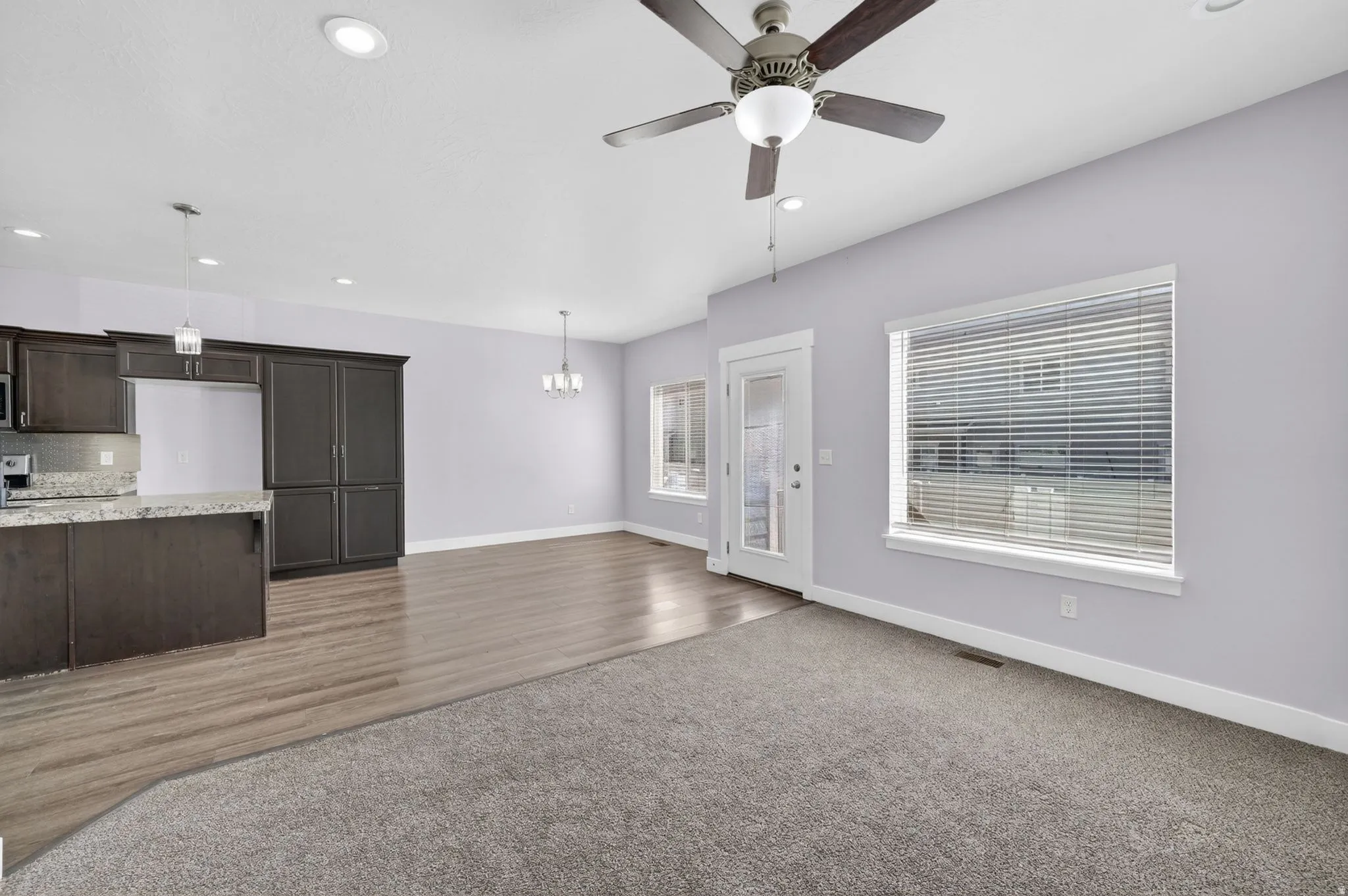 Open concept living area featuring wood-finish flooring, a ceiling fan with integrated lighting, and recessed ceiling lights