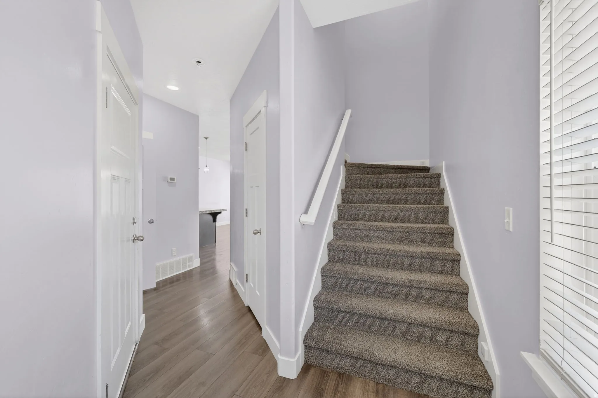 Carpeted staircase with white handrail