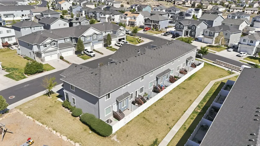 Townhome-style residences featuring light gray siding and dark gray shingle roofing