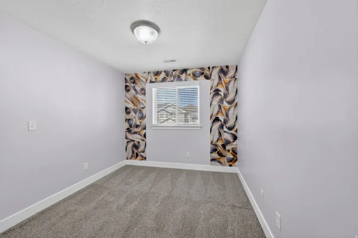 Room featuring gray carpeting, light lavender walls, and white baseboards