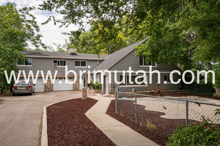 Multi-level residence featuring gray siding with stone veneer accents