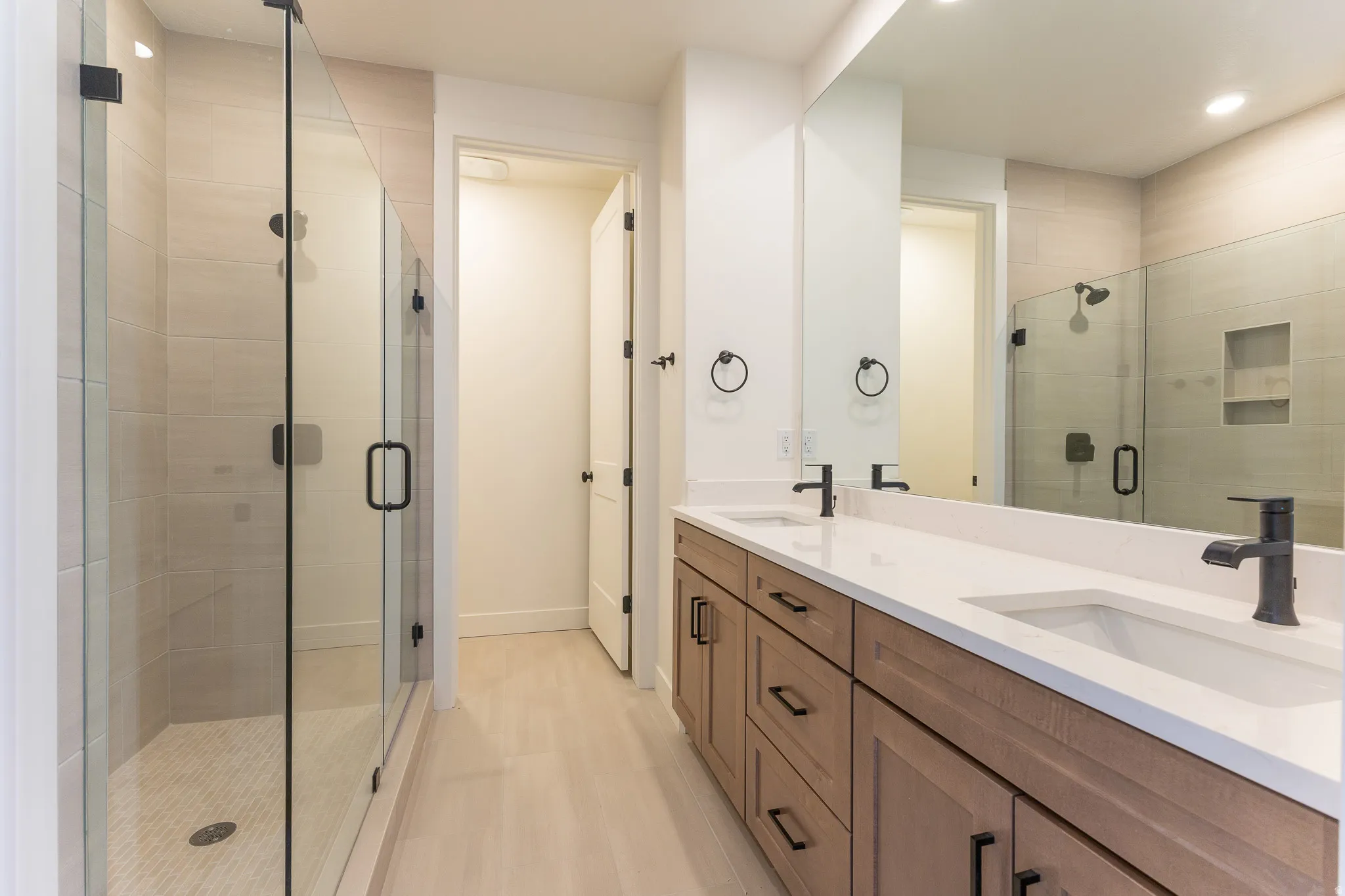 Dual vanity with white countertops, undermount sinks, and matte black fixtures