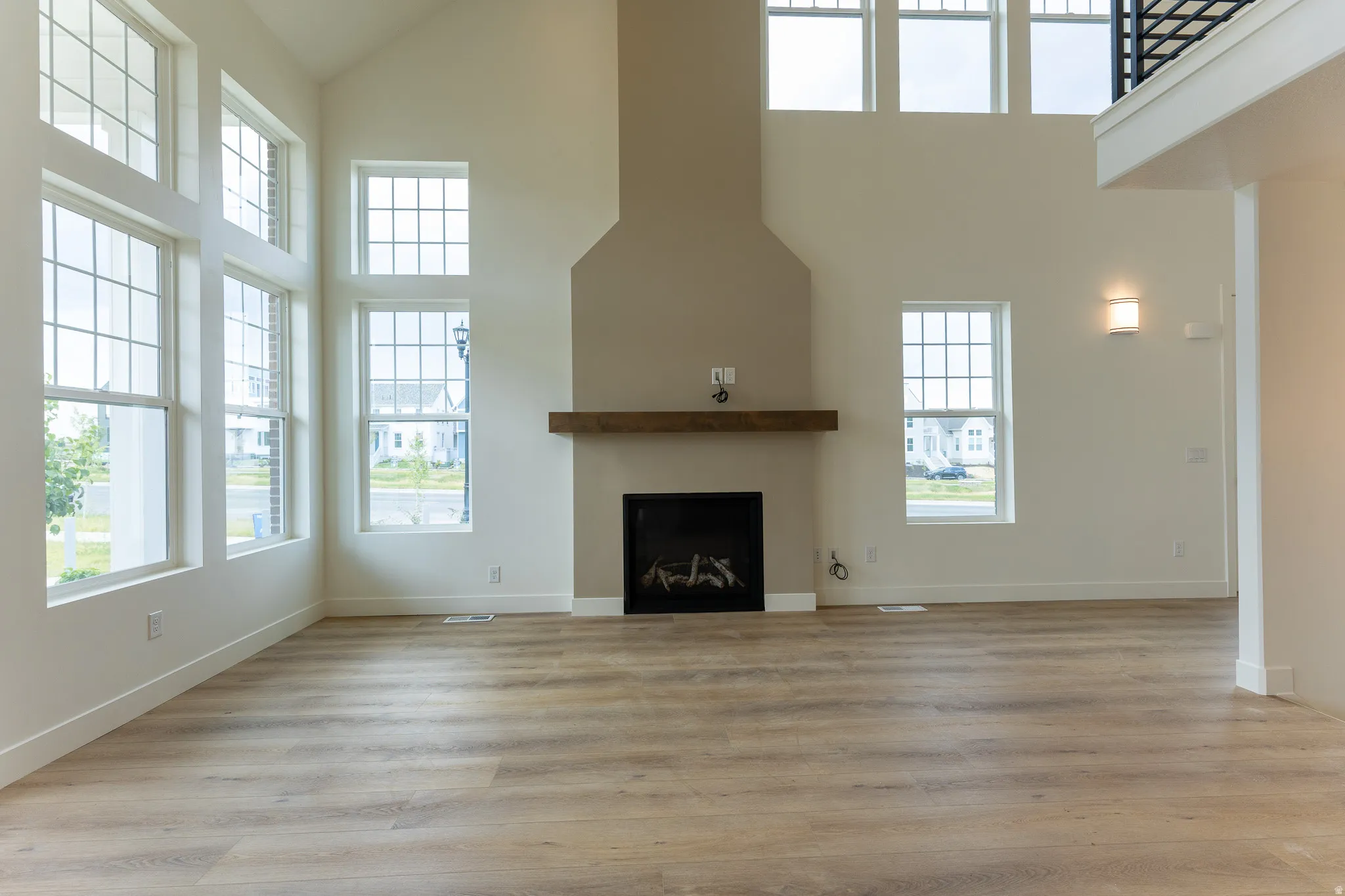Spacious living area featuring a vaulted ceiling and an abundance of natural light from multi-story windows