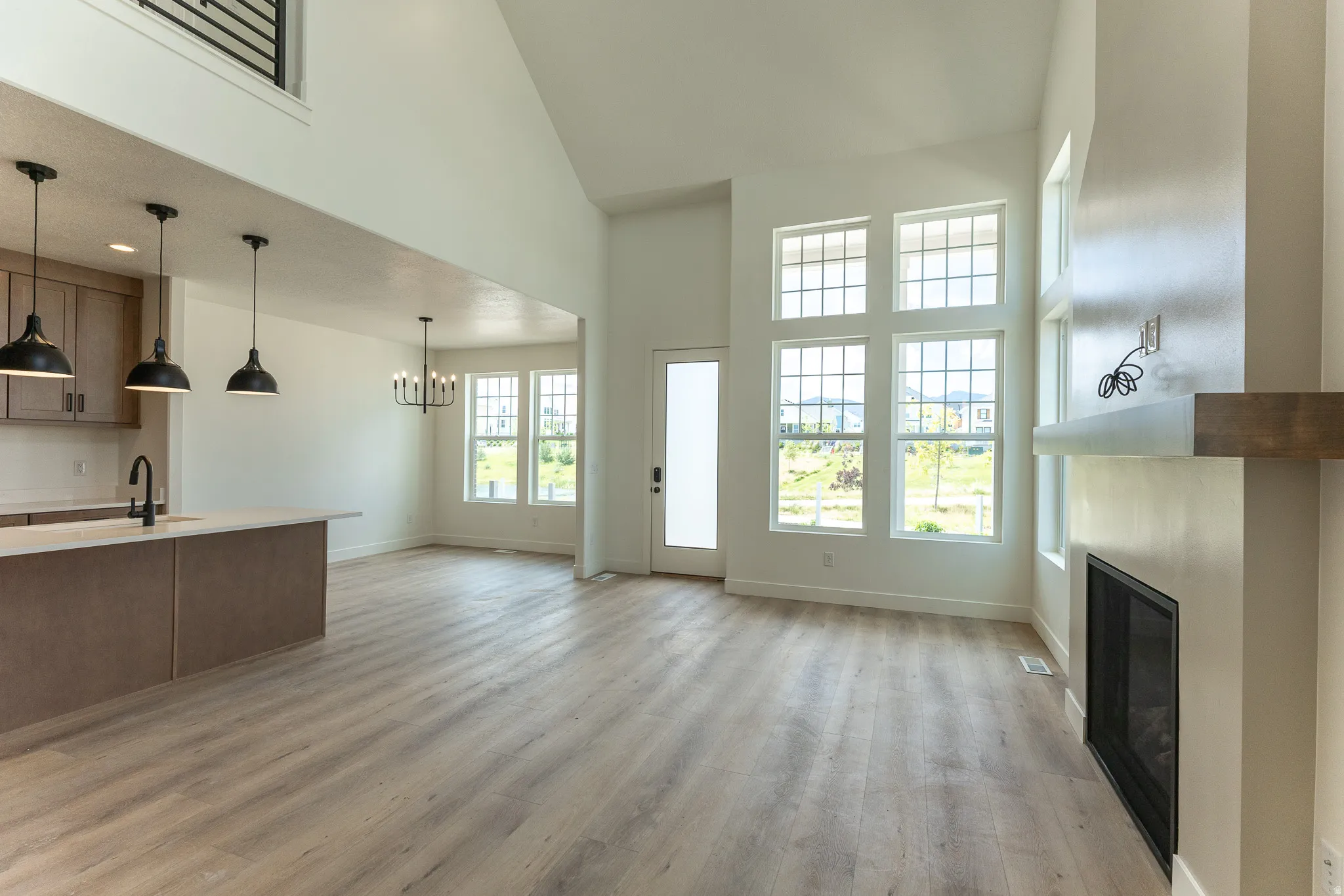 Spacious open-concept living area featuring a vaulted ceiling and wood-finish flooring