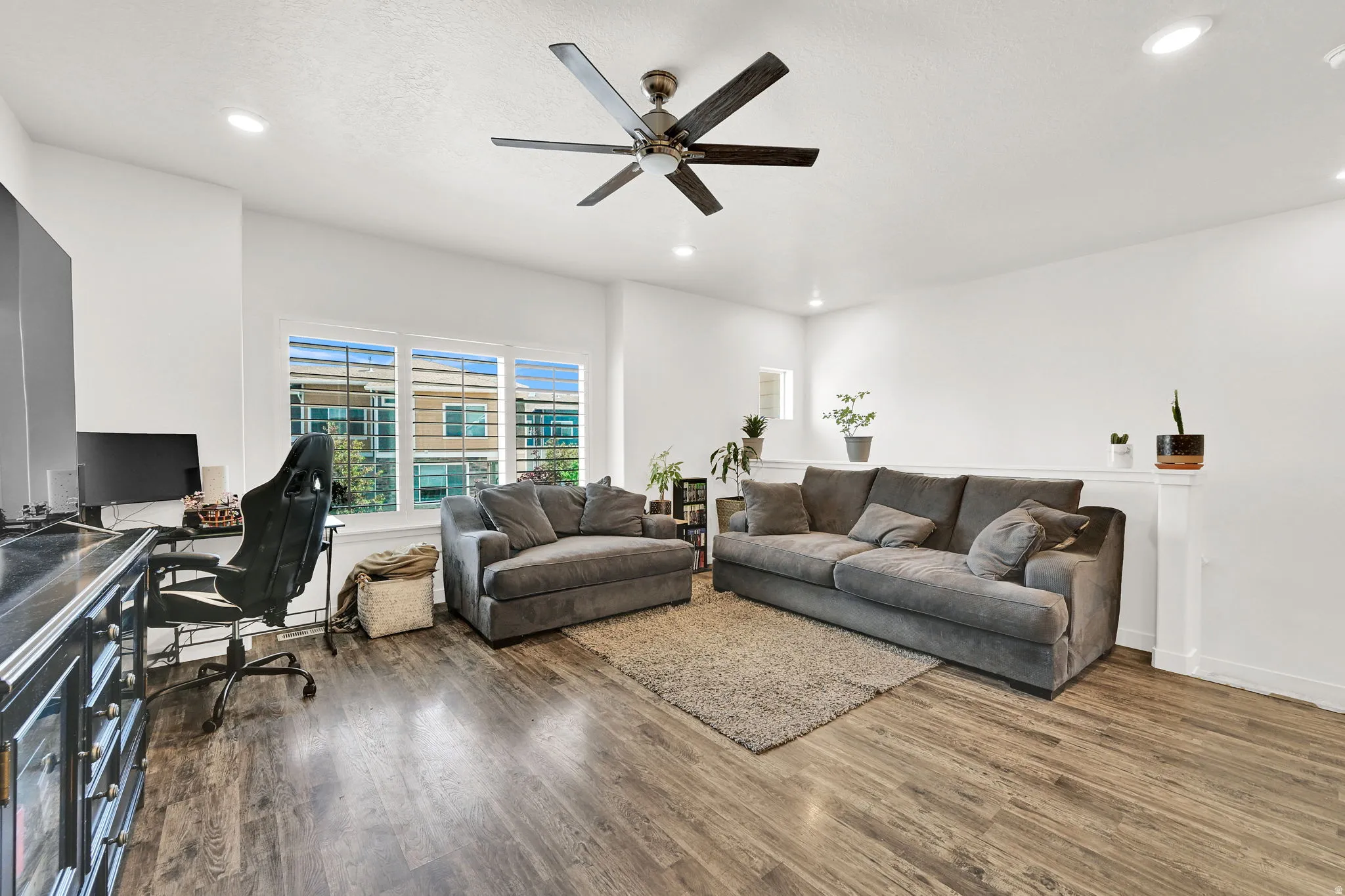 Spacious living area featuring wood-finish flooring and recessed lighting