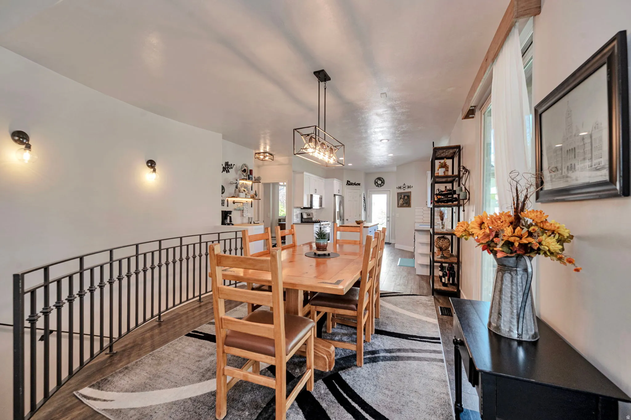 Dining area featuring a rectangular wood-finish table, an overhead linear light fixture, and wood-finish flooring
