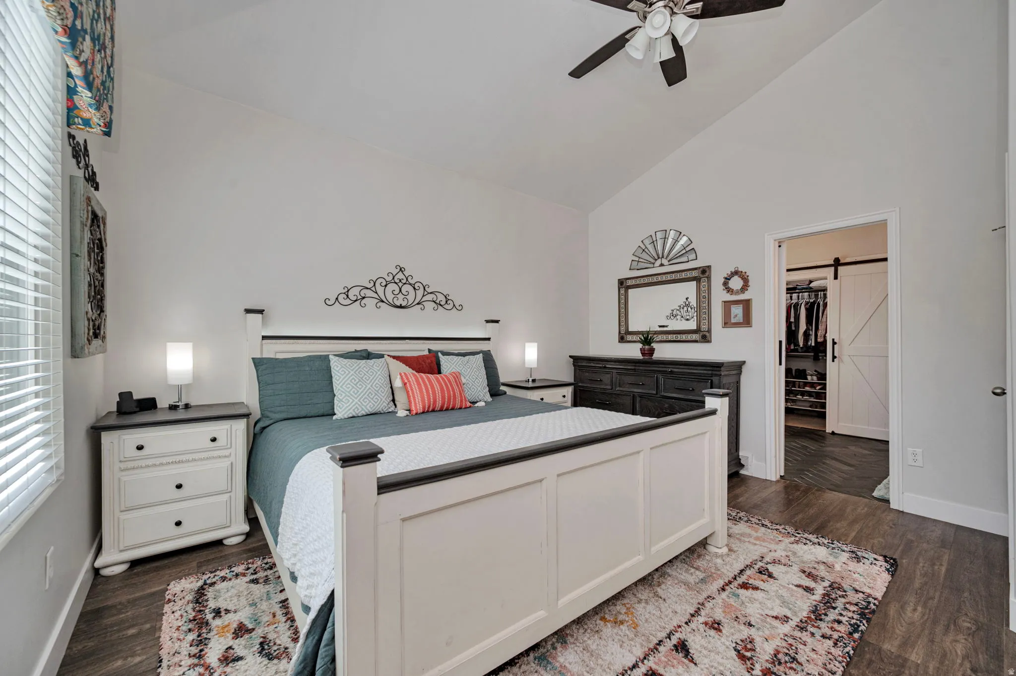 Vaulted ceiling bedroom featuring wood-finish flooring and a ceiling fan