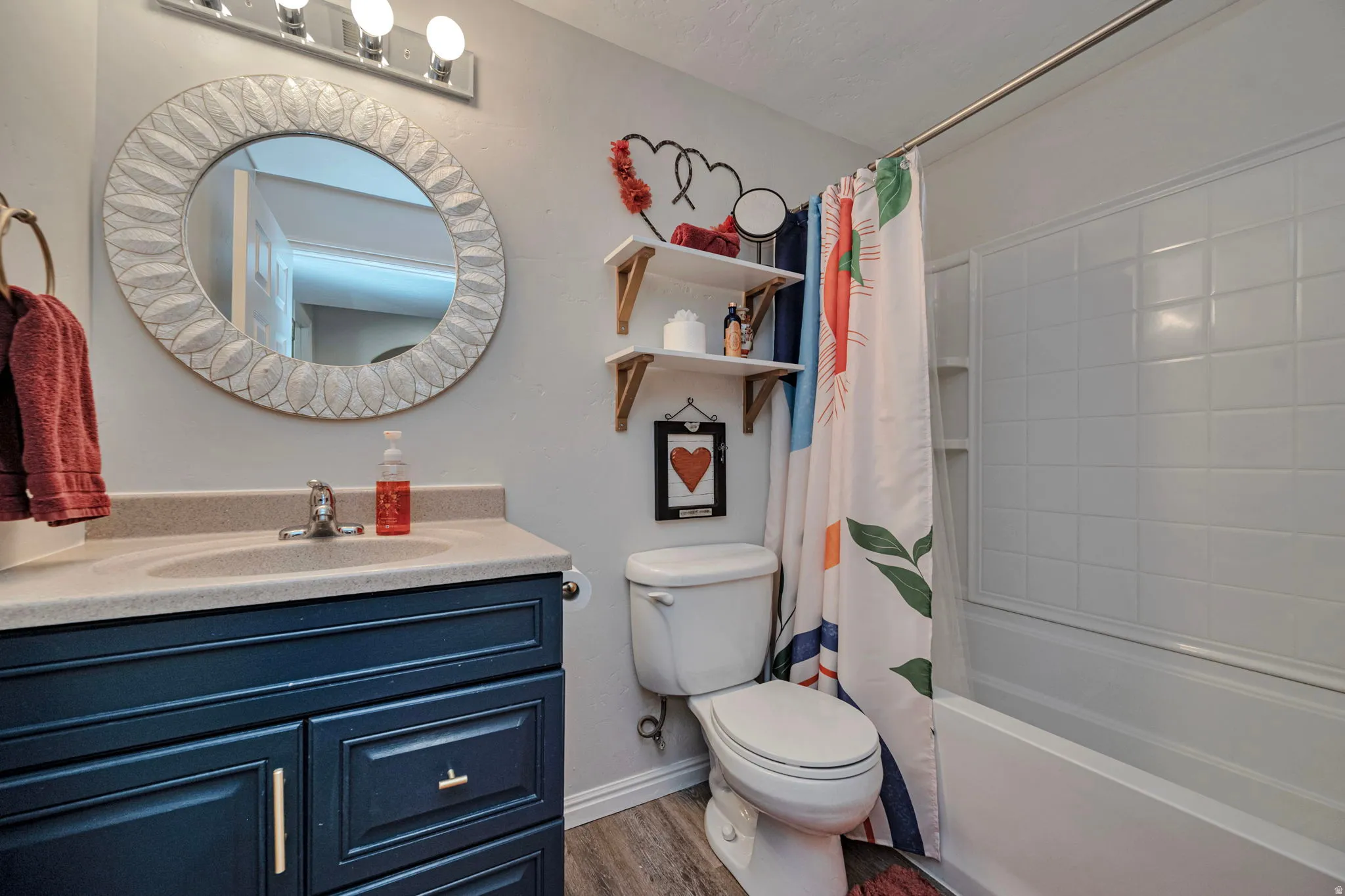 Bathroom with a deep blue vanity, a built-in sink, and a large circular mirror