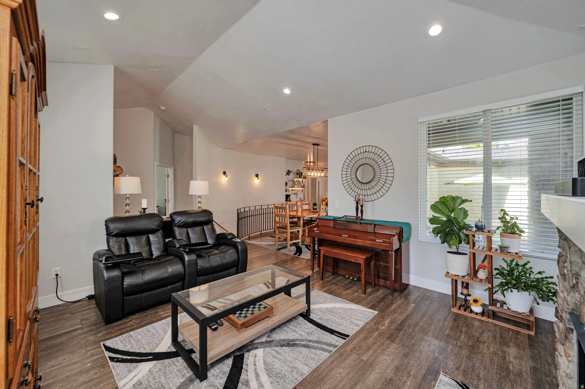 Living area featuring wood-finish flooring, recessed lighting, and a stone-clad fireplace