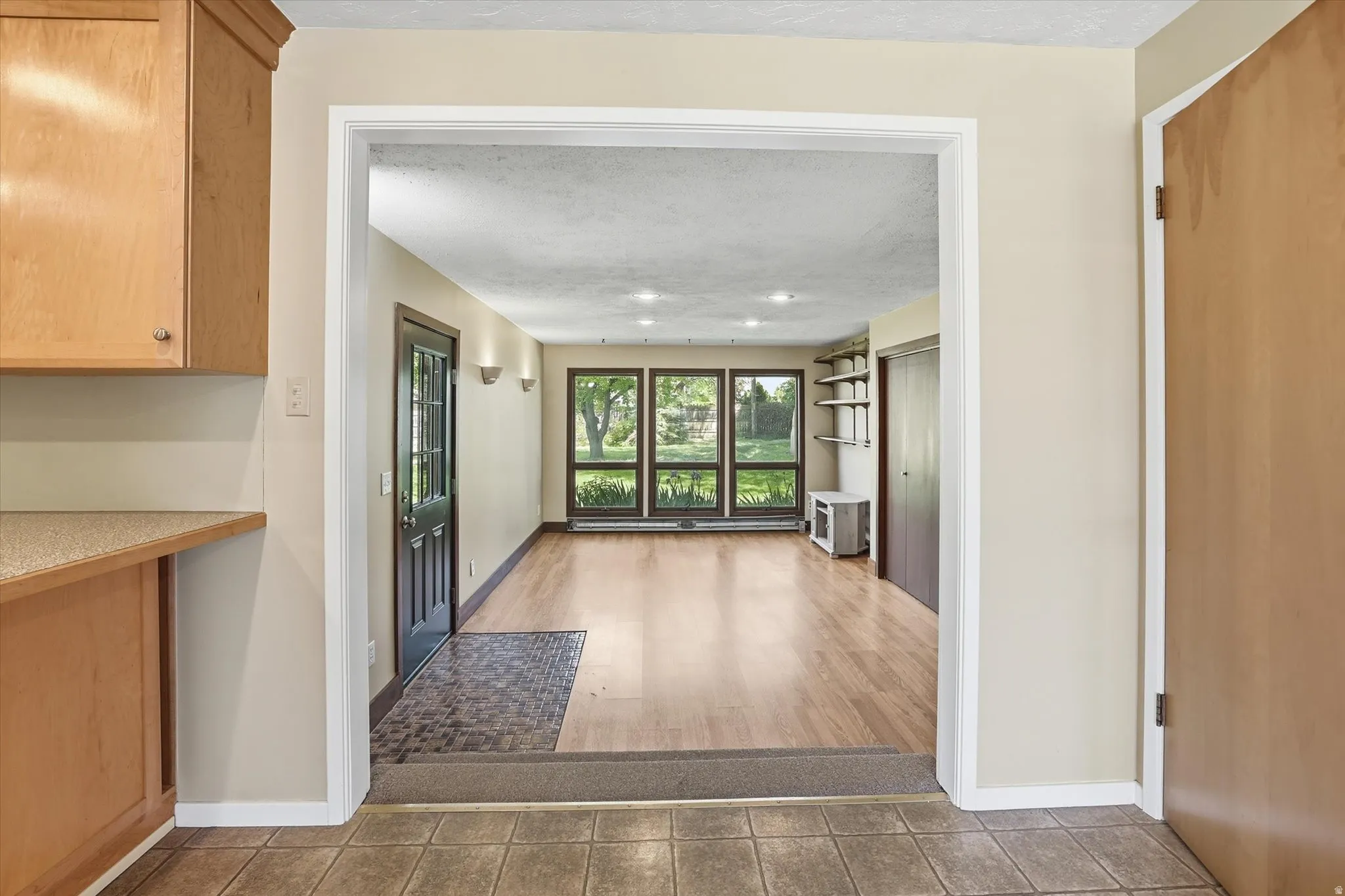 Room featuring wood-finish flooring, recessed lighting, and a wall of three large windows