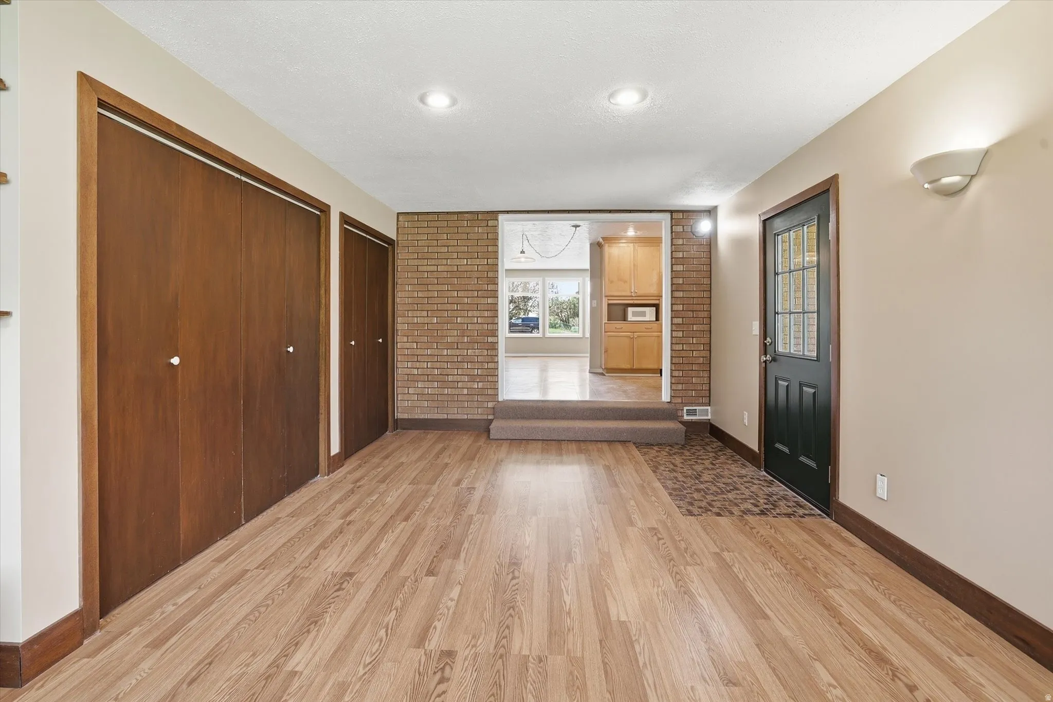 Expansive room featuring wood-finish flooring, two large bi-fold closets, and recessed lighting