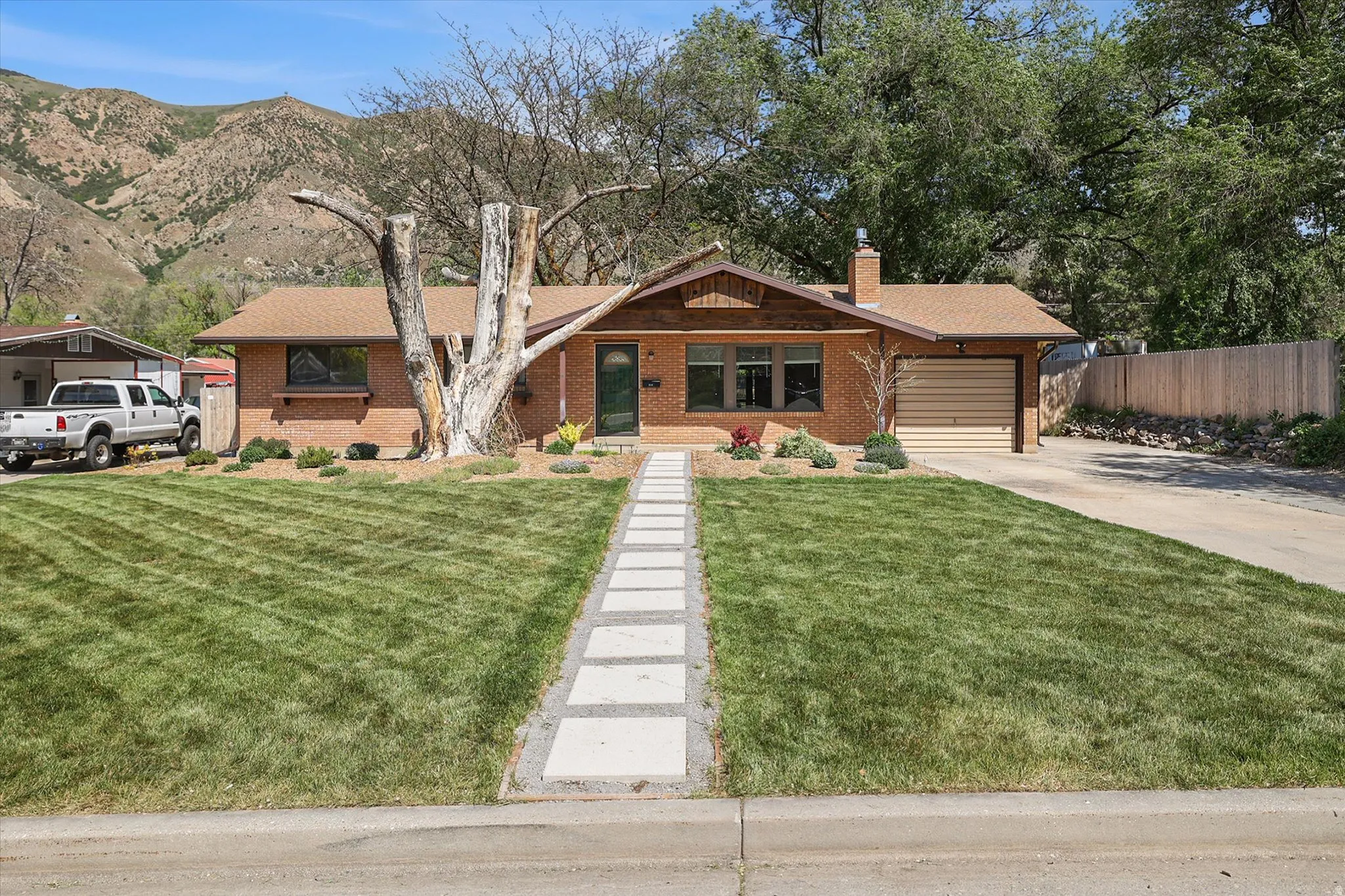 Brick exterior home featuring a neutral-toned garage door and a front door with a window pane