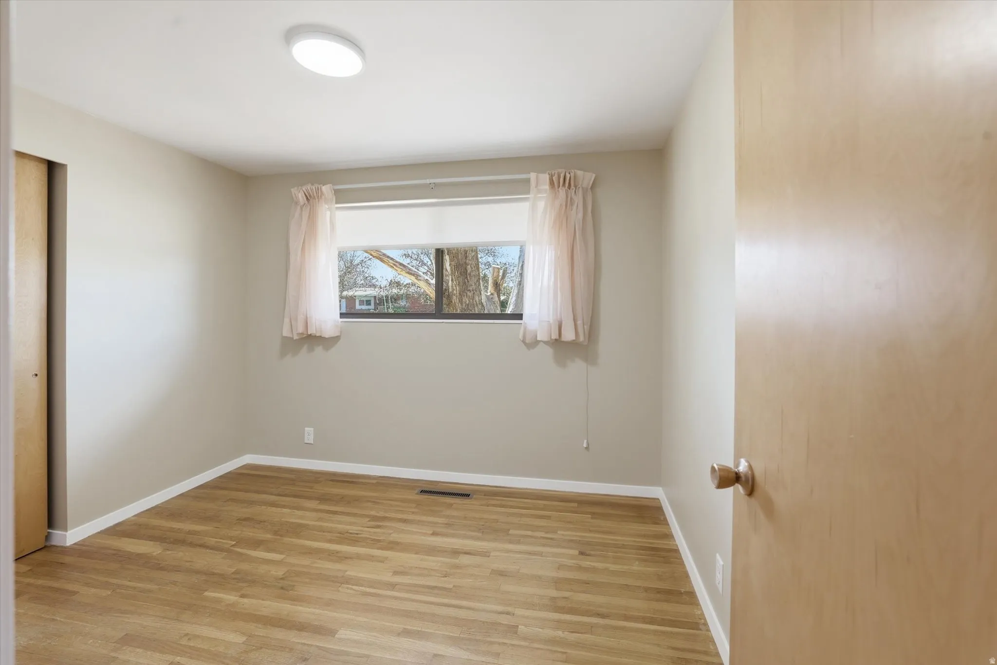 Light-toned wood-finish flooring complements neutral wall tones
