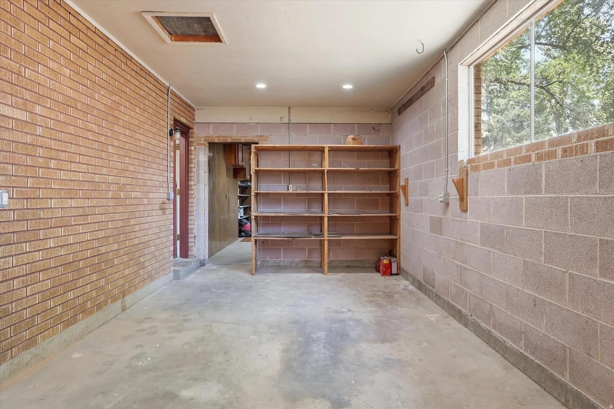 Versatile interior space featuring a concrete floor, exposed brick wall, and concrete block wall construction