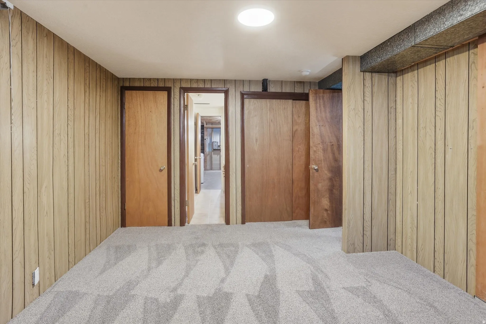Interior space featuring wood paneling, light gray patterned carpeting, and recessed ceiling lighting