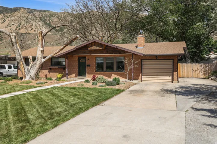 Brick facade residence featuring a front entry, single-car garage, concrete driveway, and front lawn