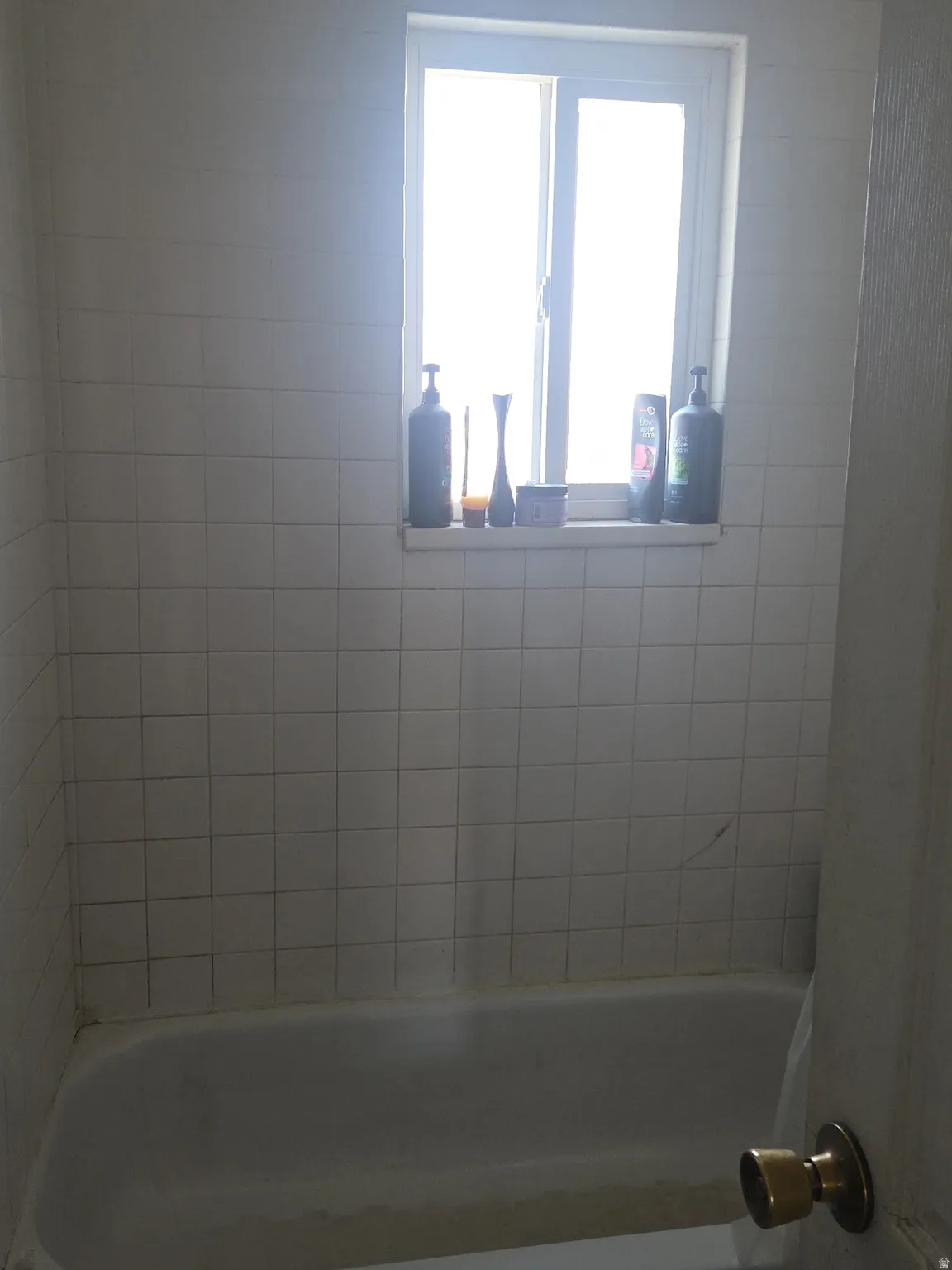 White tiled shower surround with an integrated window featuring a single-pane design