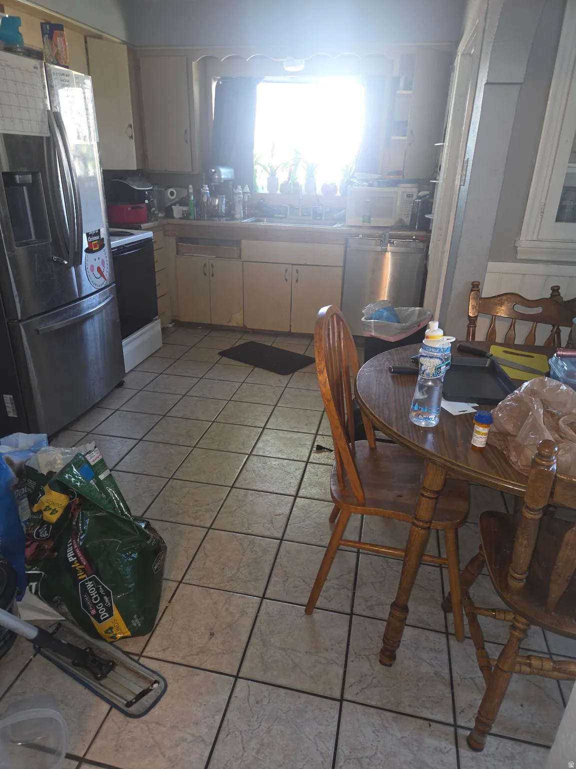 Kitchen featuring tile flooring, white cabinetry, and stainless steel appliances