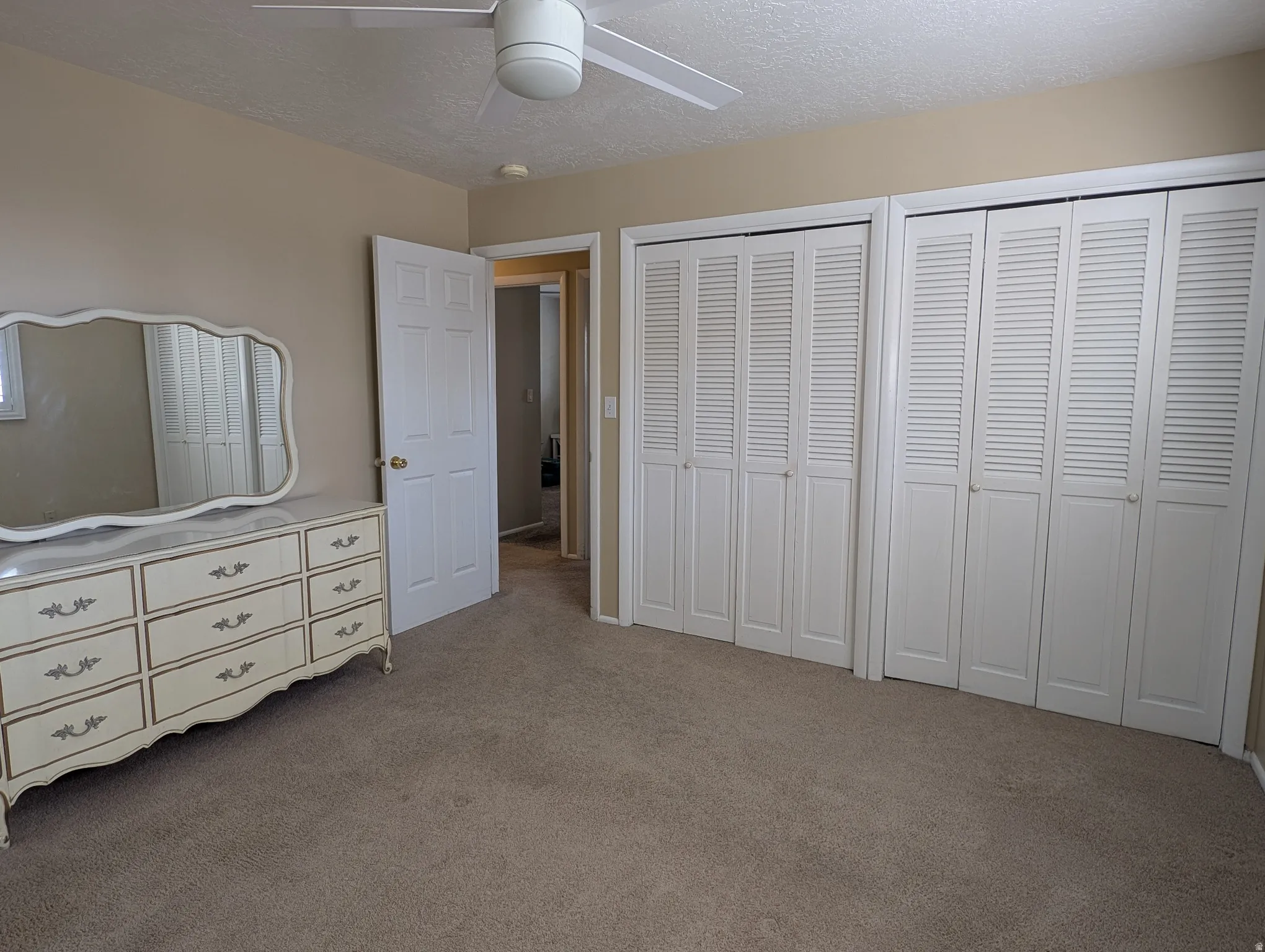 Master bedroom with wall-to-wall carpeting and neutral wall tones