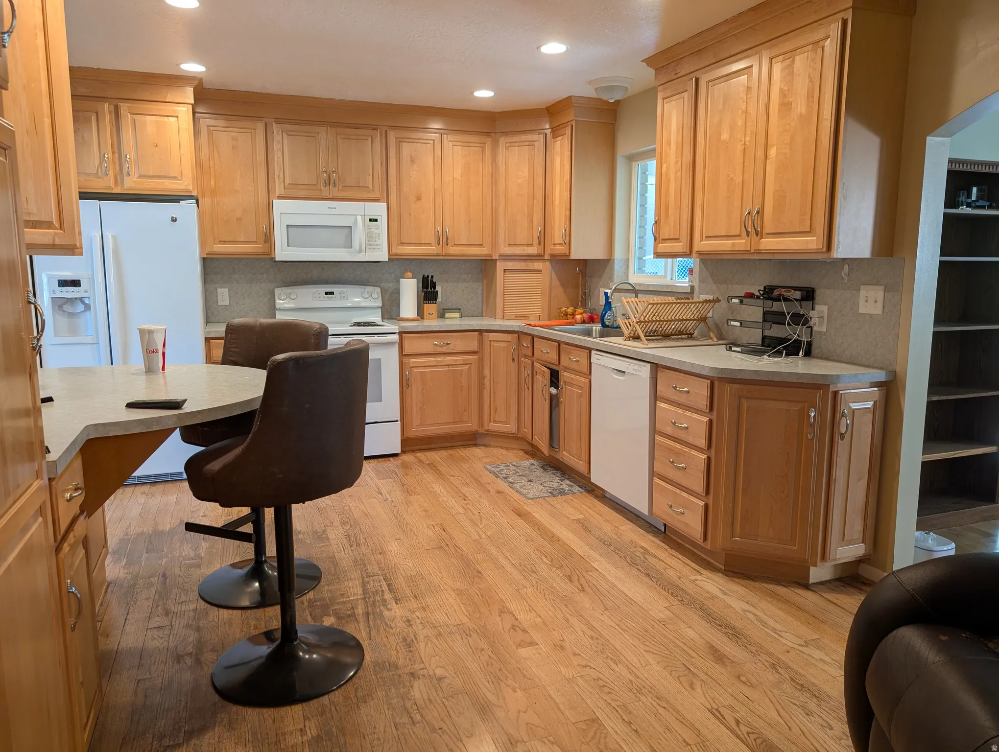 Spacious kitchen featuring light wood cabinetry, light-toned countertops, and wood-finish flooring