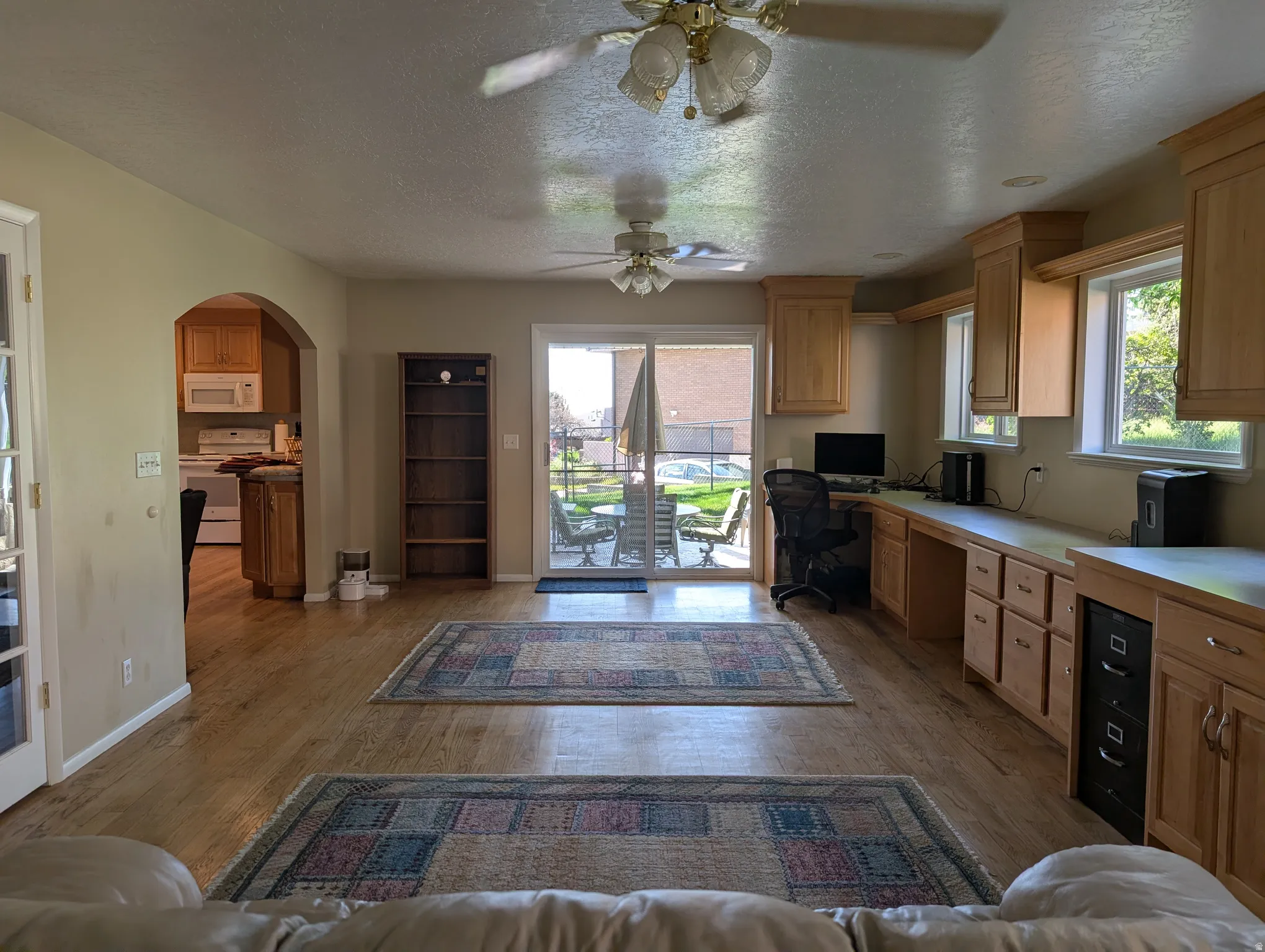 Spacious family room featuring wood-finish flooring and an arched doorway