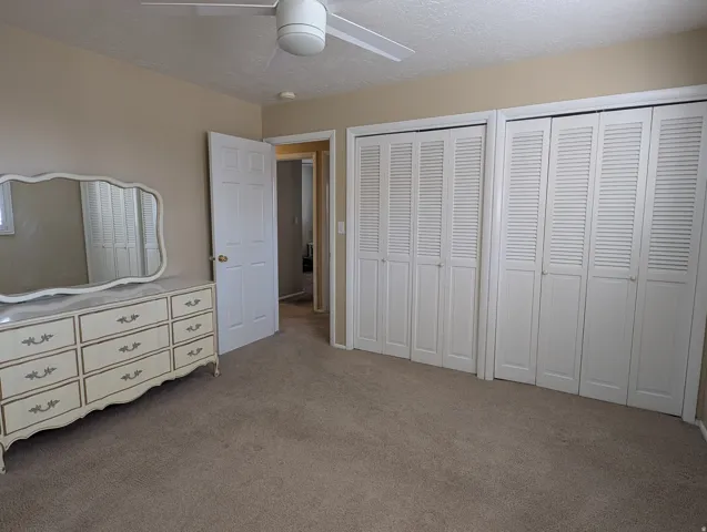 Master bedroom with wall-to-wall carpeting and neutral wall tones