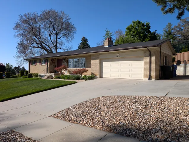 Ranch-style residence featuring a brick facade, attached two-car garage, and a concrete driveway
