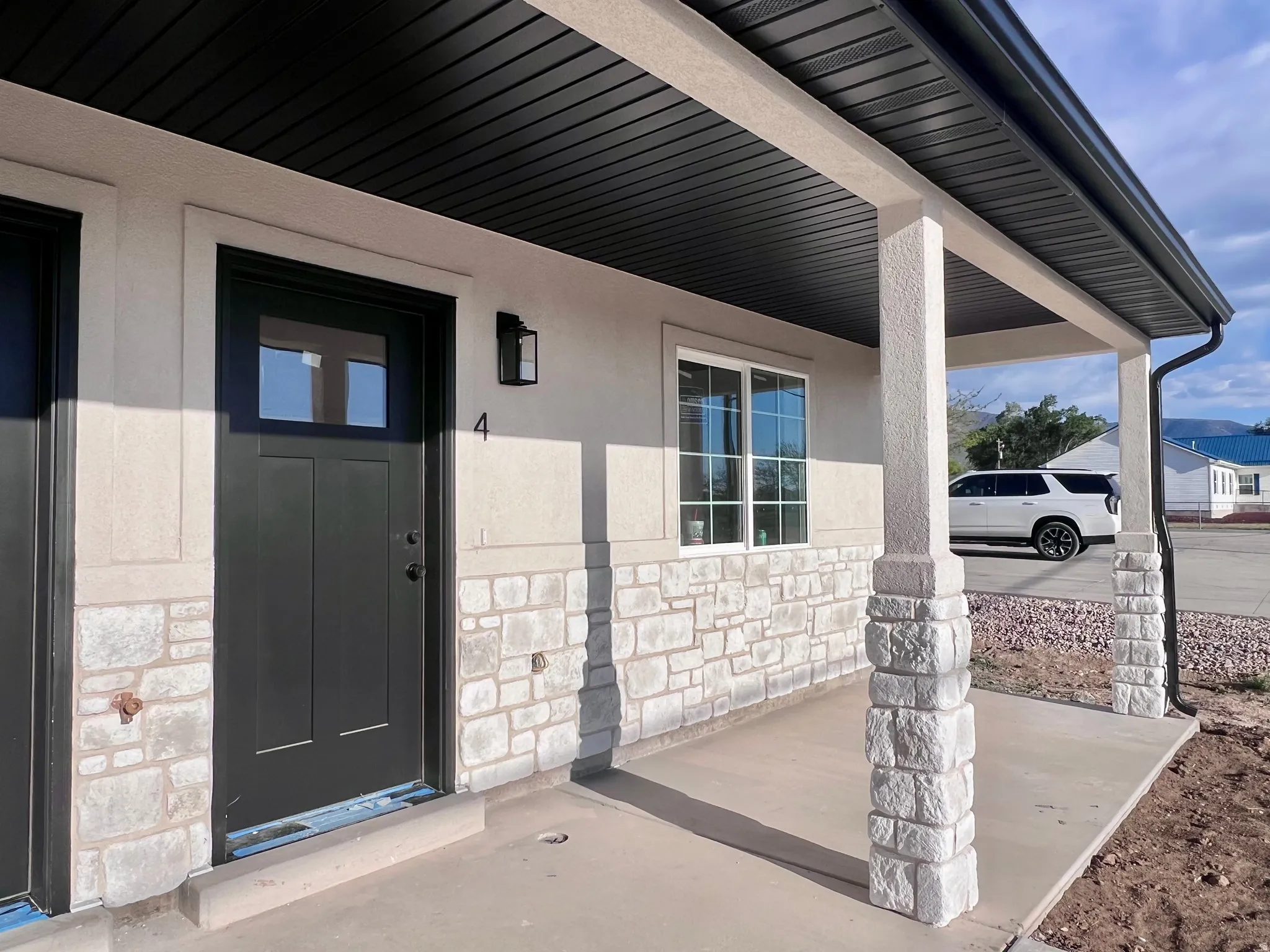 Exterior facade with light stucco and stone veneer accents