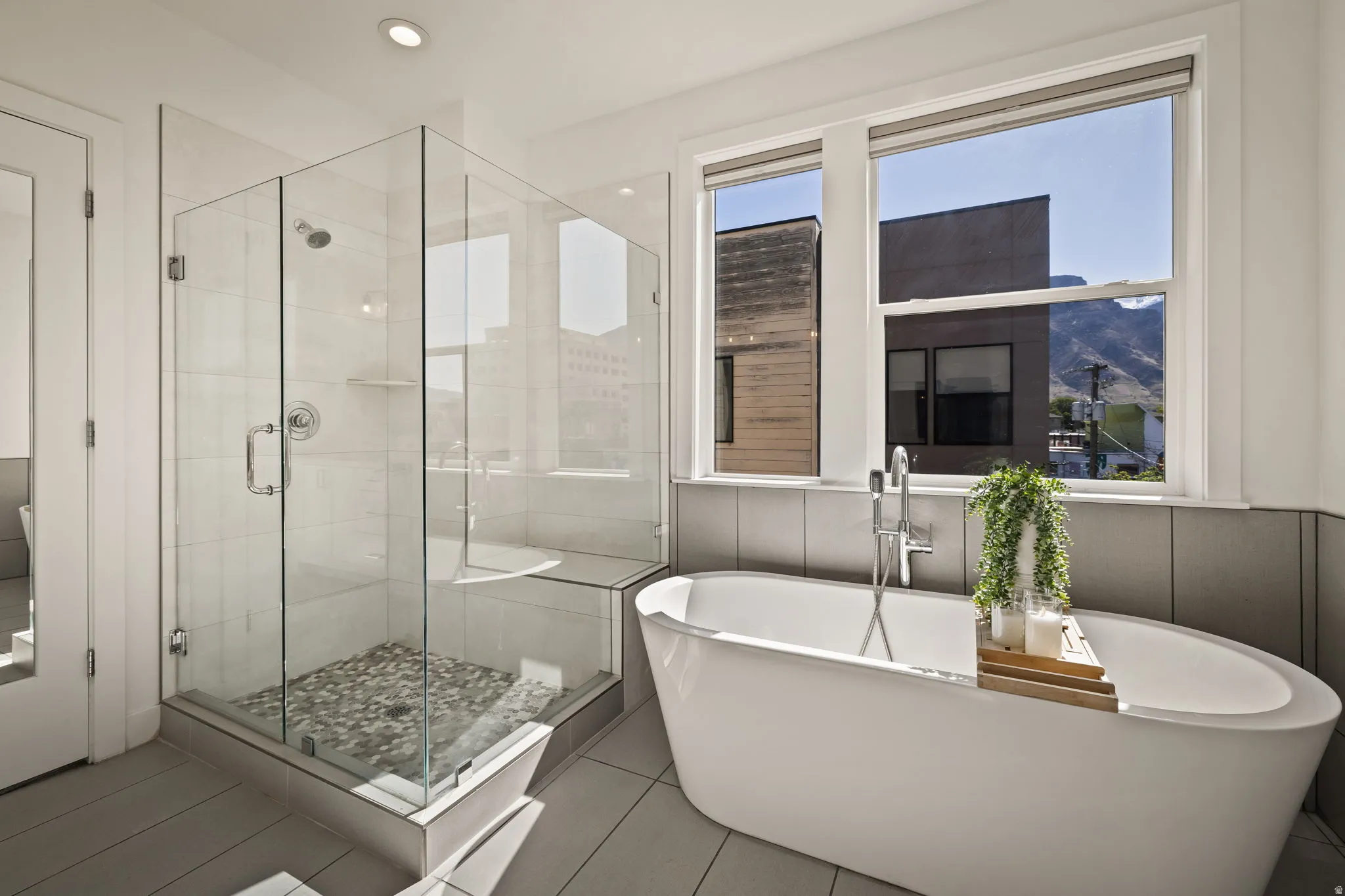 Full bath featuring a shower stall, a freestanding tub, light tile patterned floors, and recessed lighting