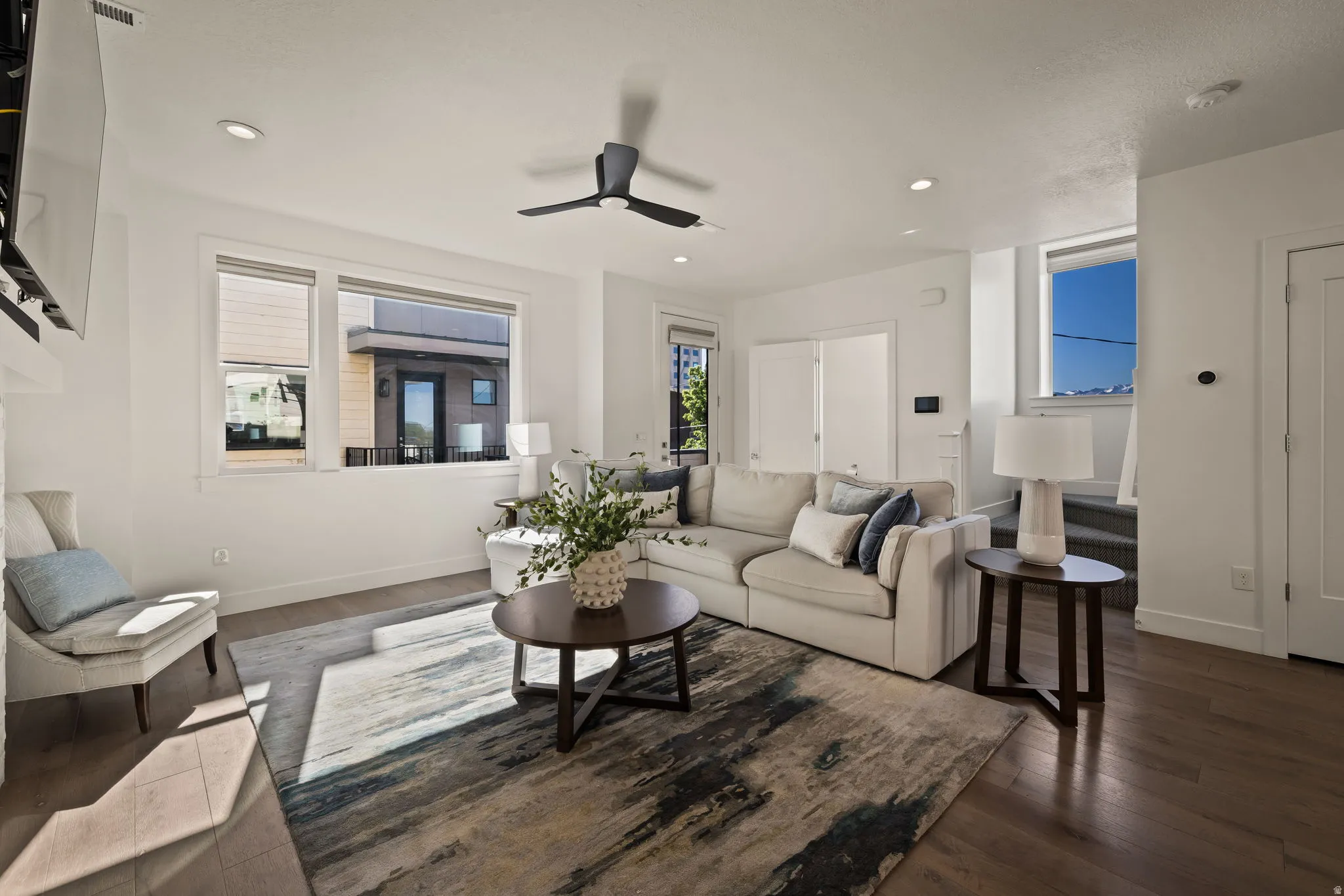 Living room with ceiling fan, dark wood-style floors, and recessed lighting