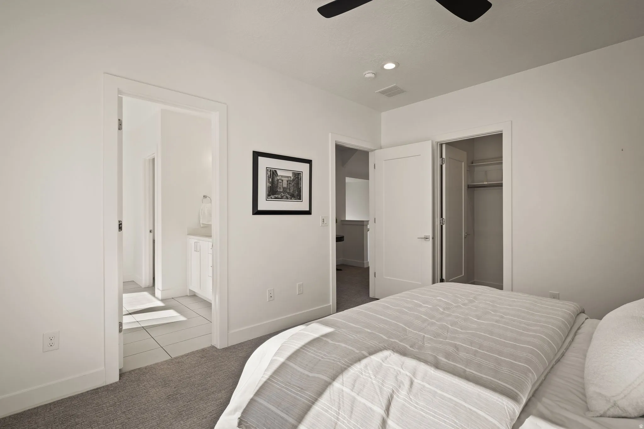 Carpeted bedroom featuring ceiling fan, a walk in closet, and recessed lighting