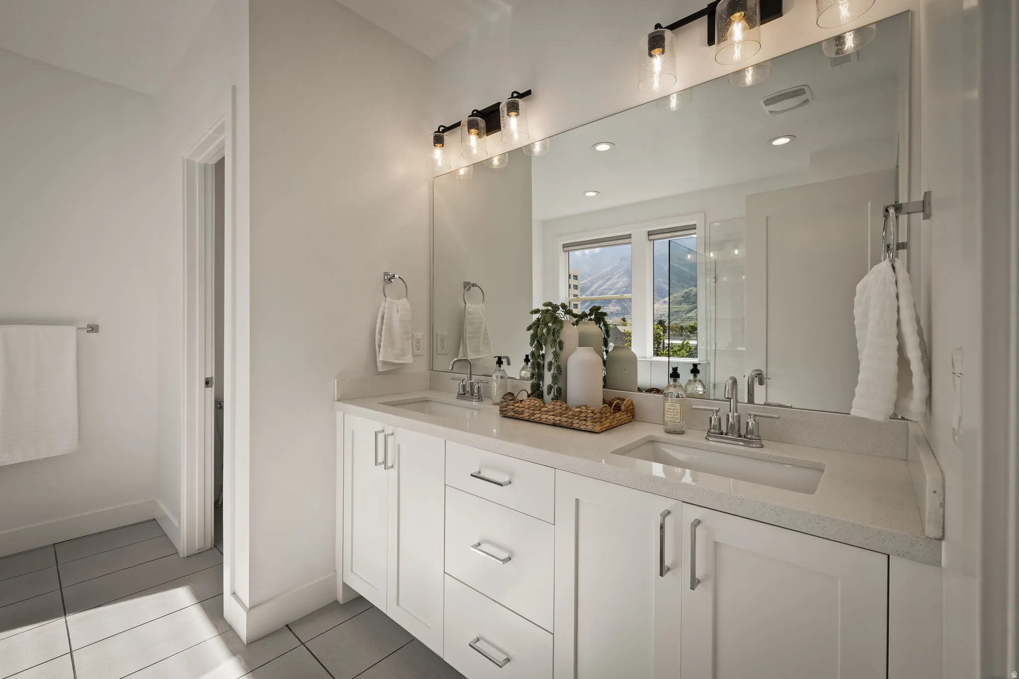 Full bath with double vanity, light tile patterned flooring, and recessed lighting