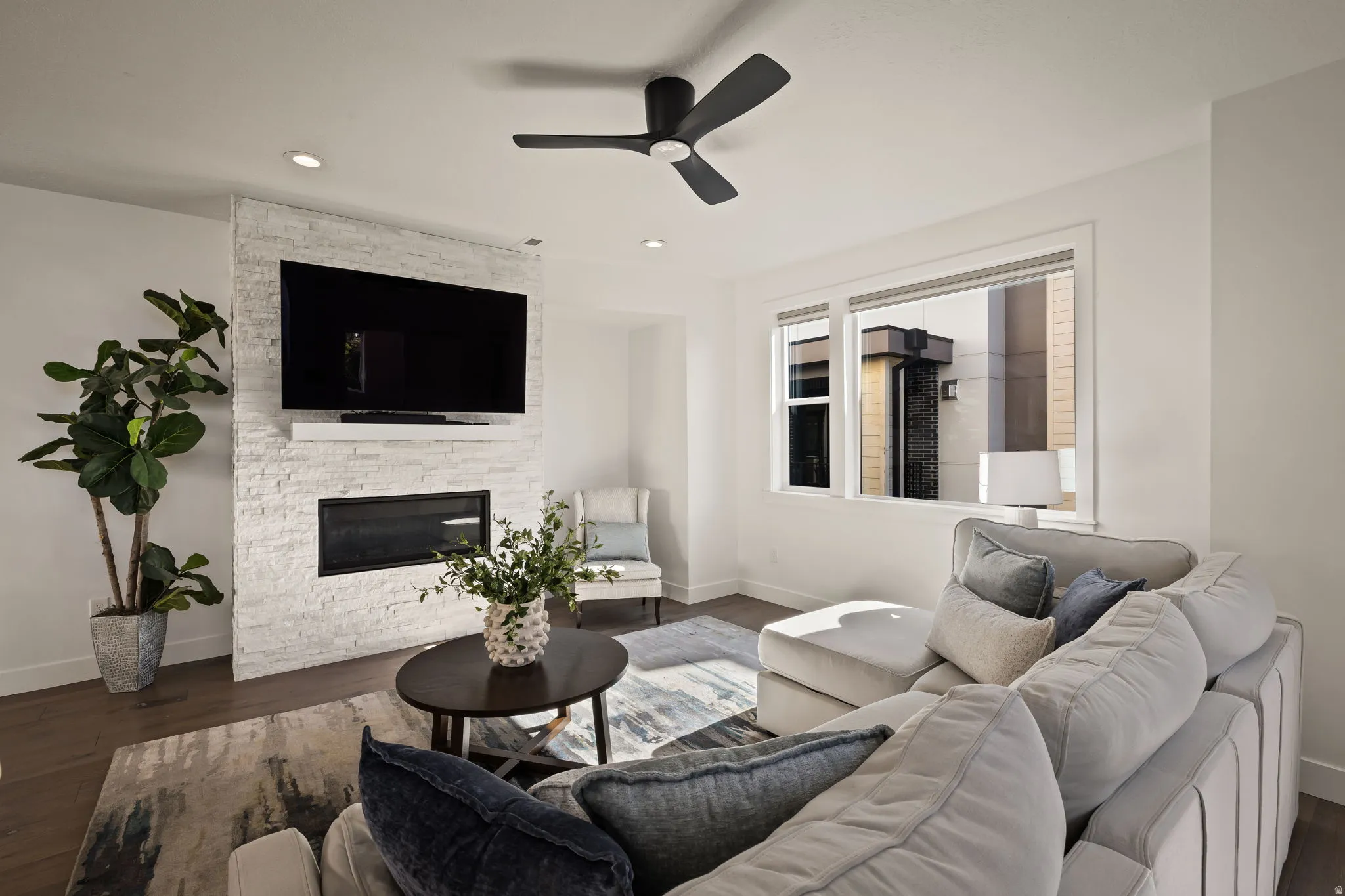 Living room with a ceiling fan, wood finished floors, a fireplace, and recessed lighting