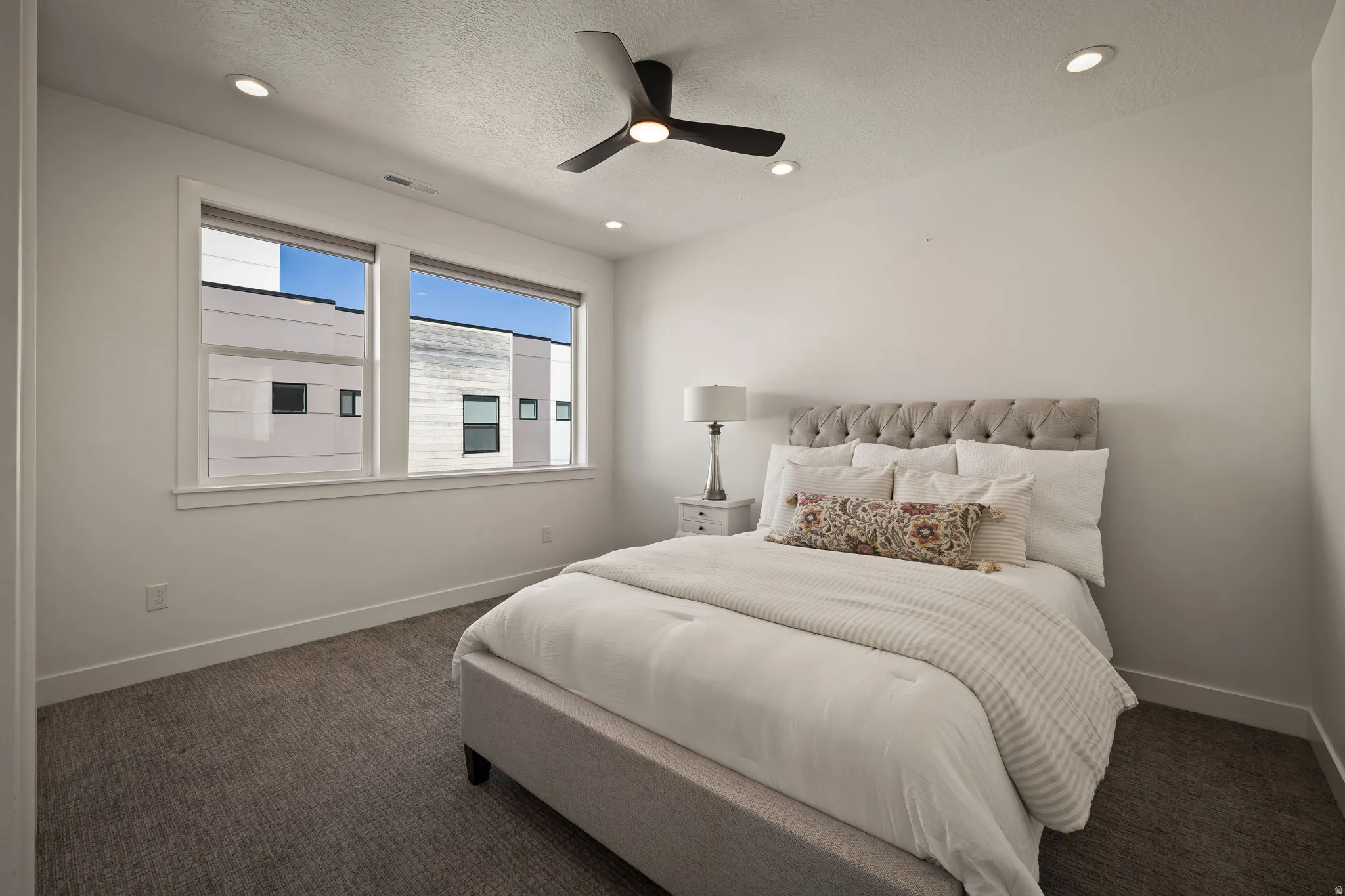 Carpeted bedroom with ceiling fan, recessed lighting, and a textured ceiling